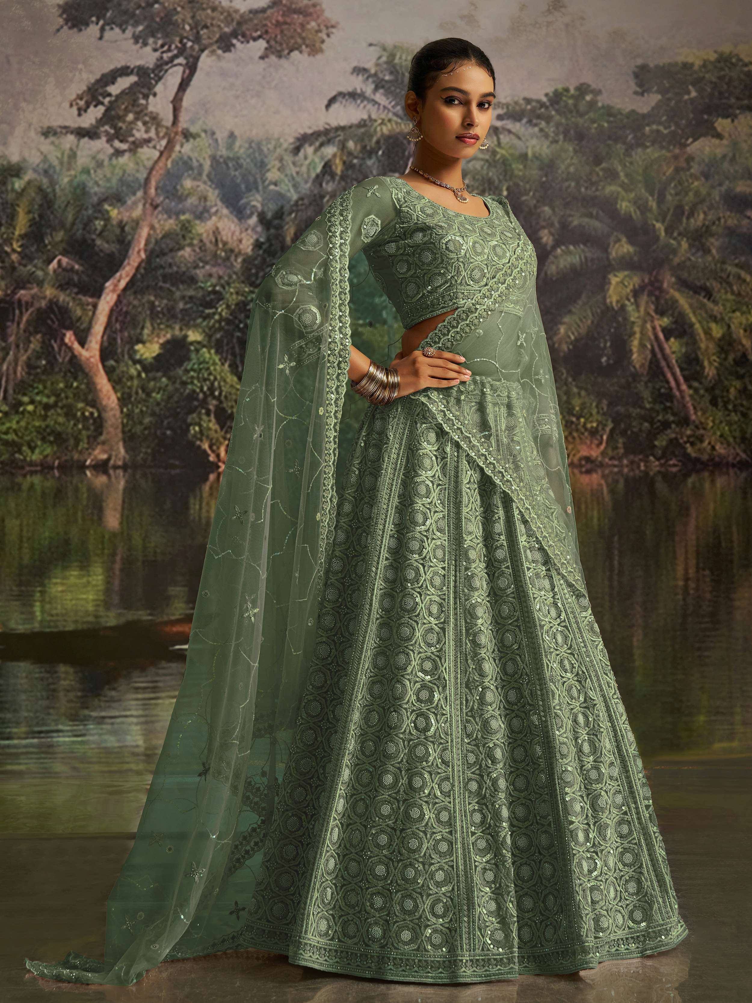 Elegant green designer lehenga choli with intricate embroidery and sheer cape, perfect for Indian ethnic occasions.