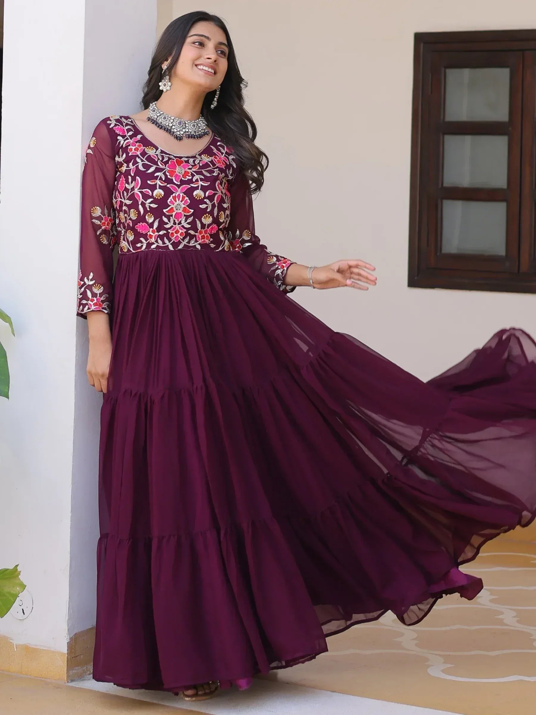 Woman in maroon embroidered ethnic gown with floral detailing, perfect for Indian occasions