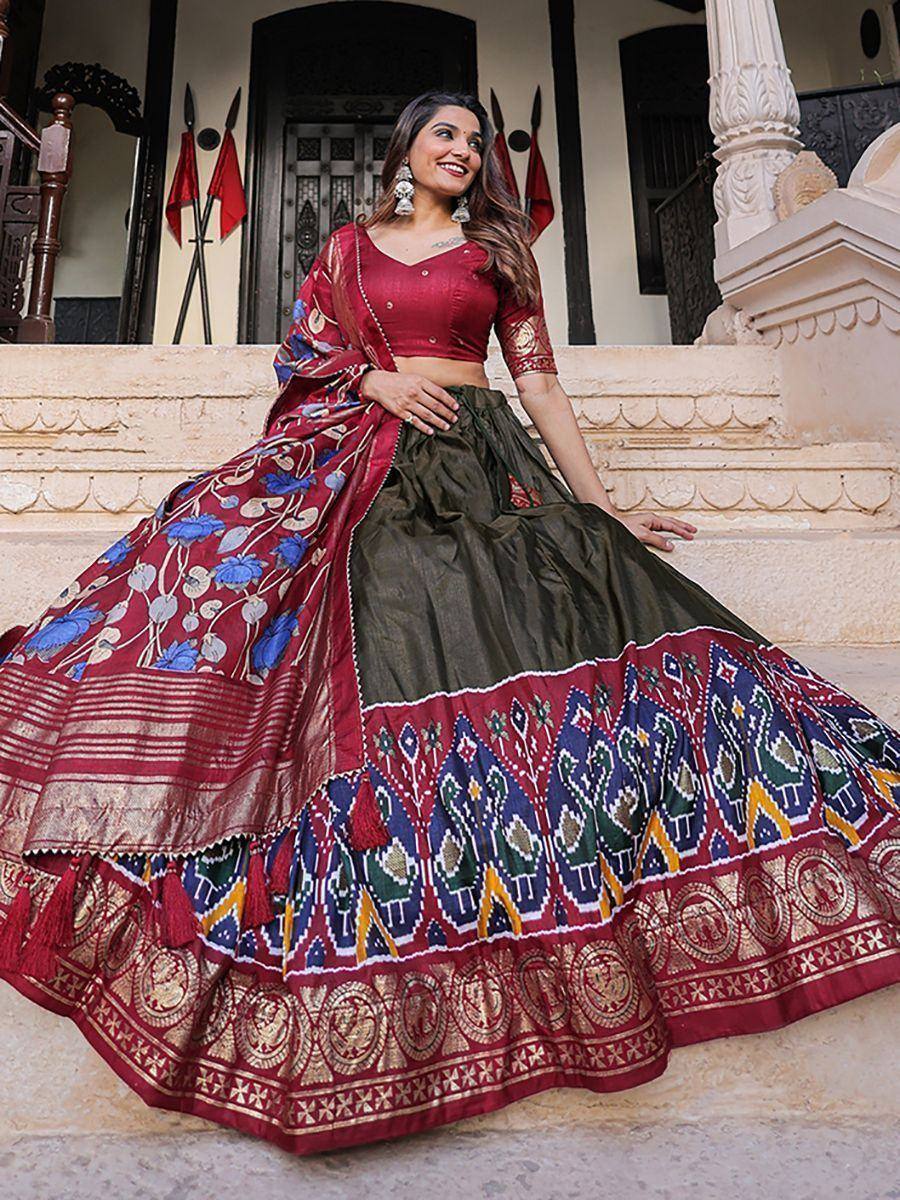 Woman in maroon and olive green designer lehenga choli with floral and ikat print, perfect for Indian ethnic wear