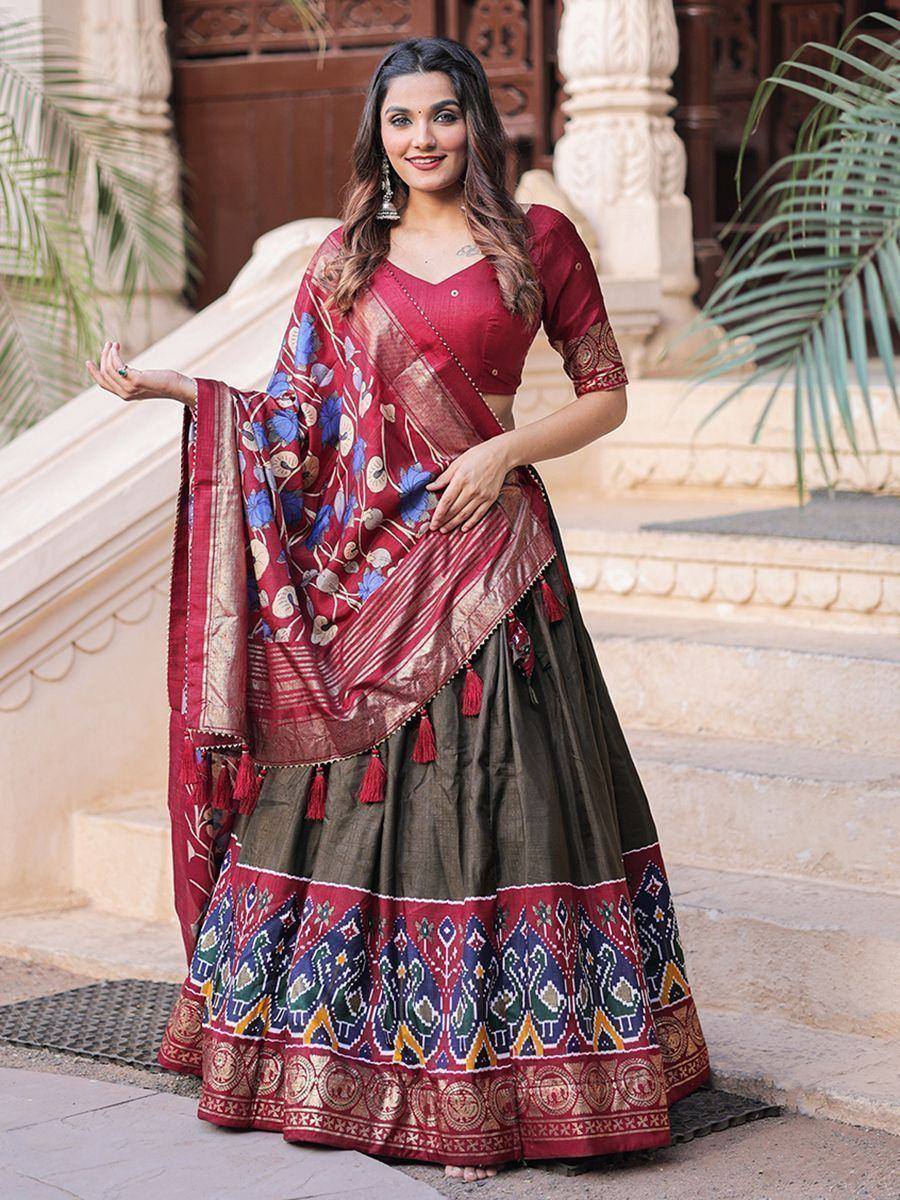Woman in maroon and olive lehenga choli with floral dupatta, ethnic Indian wear for festive occasions