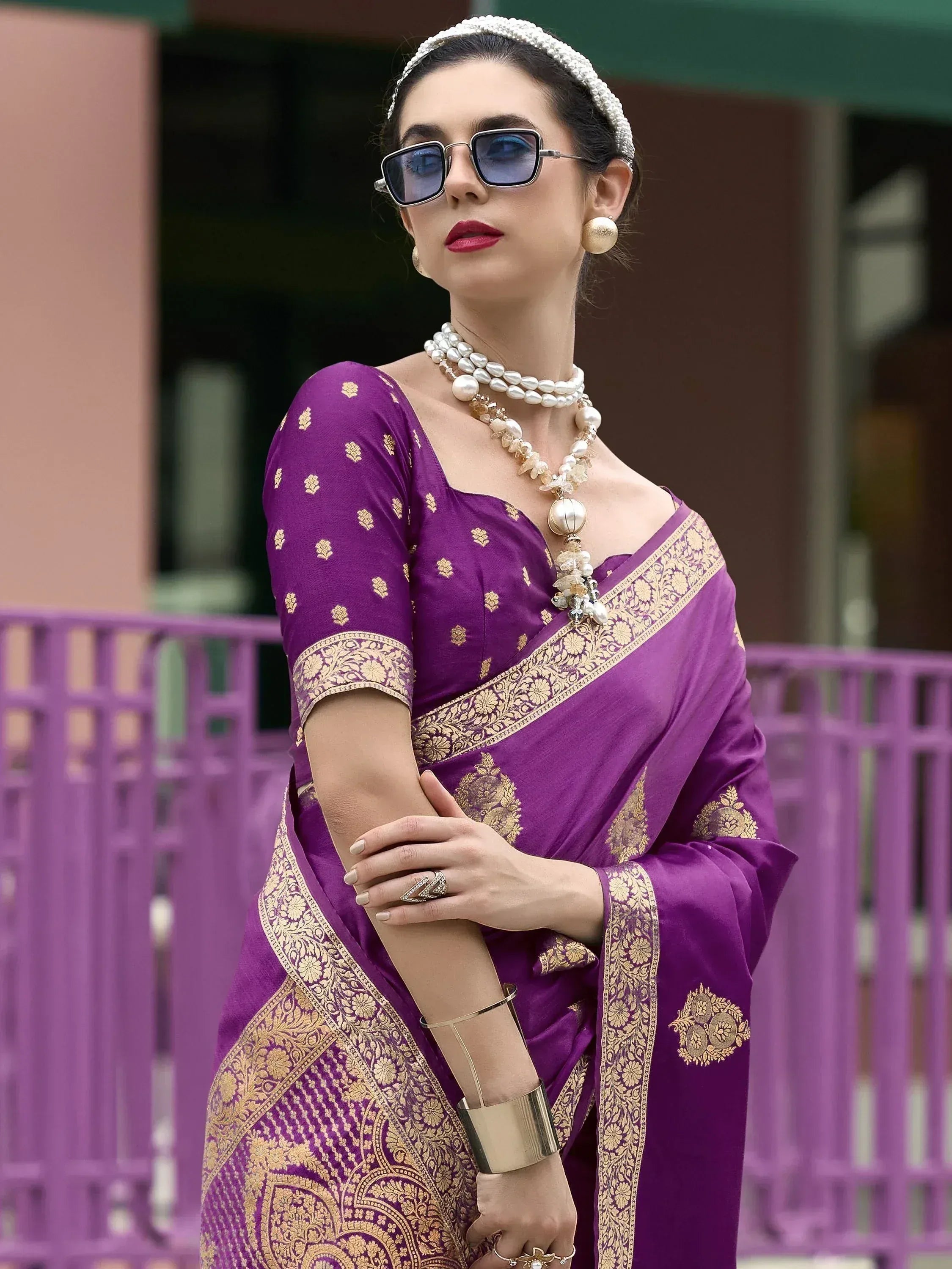 Purple designer saree with gold embroidery, styled with pearl jewelry and sunglasses for ethnic fashion