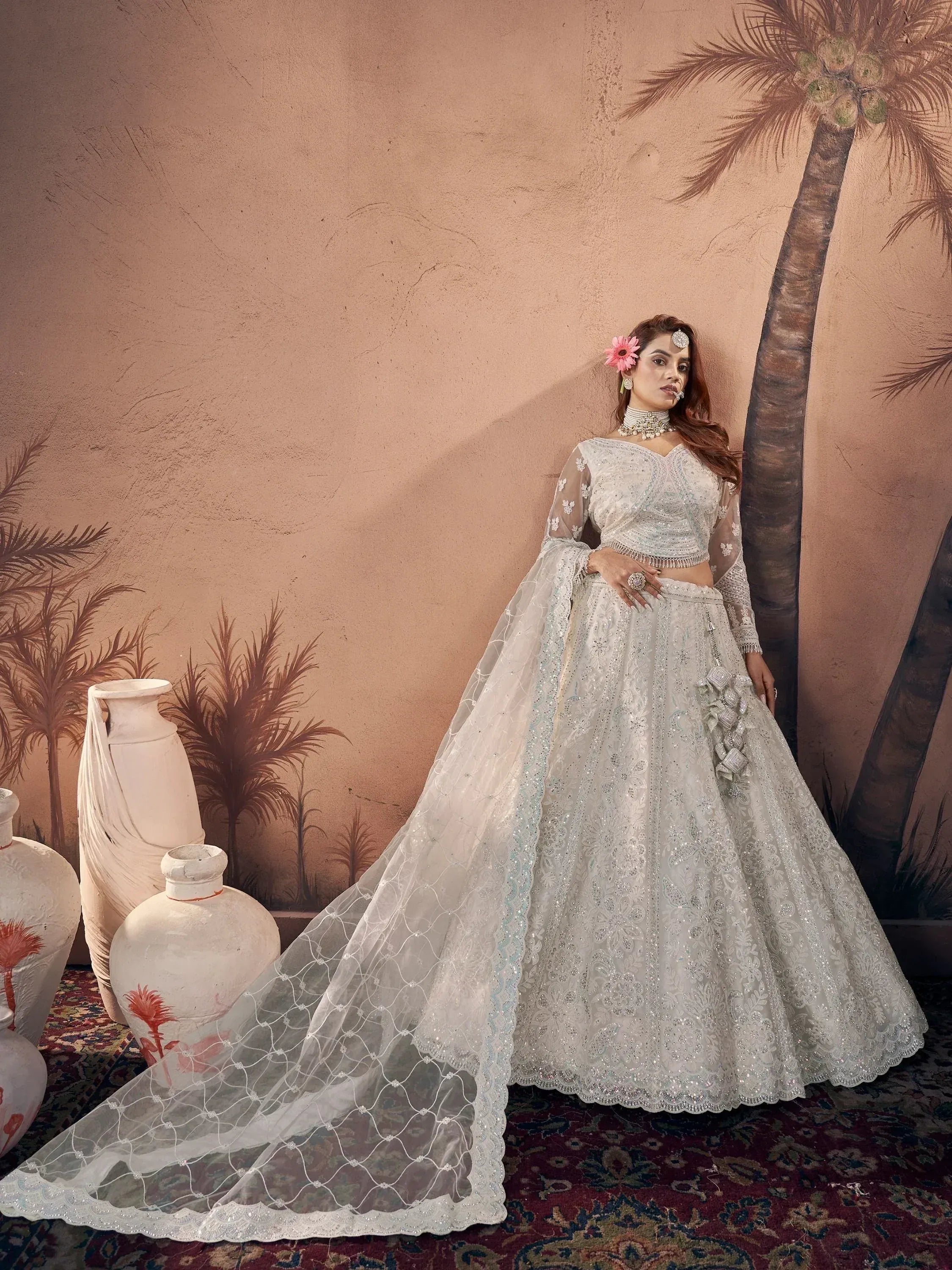 Elegant white embroidered lehenga choli with sheer cape, perfect for Indian weddings and festive occasions.
