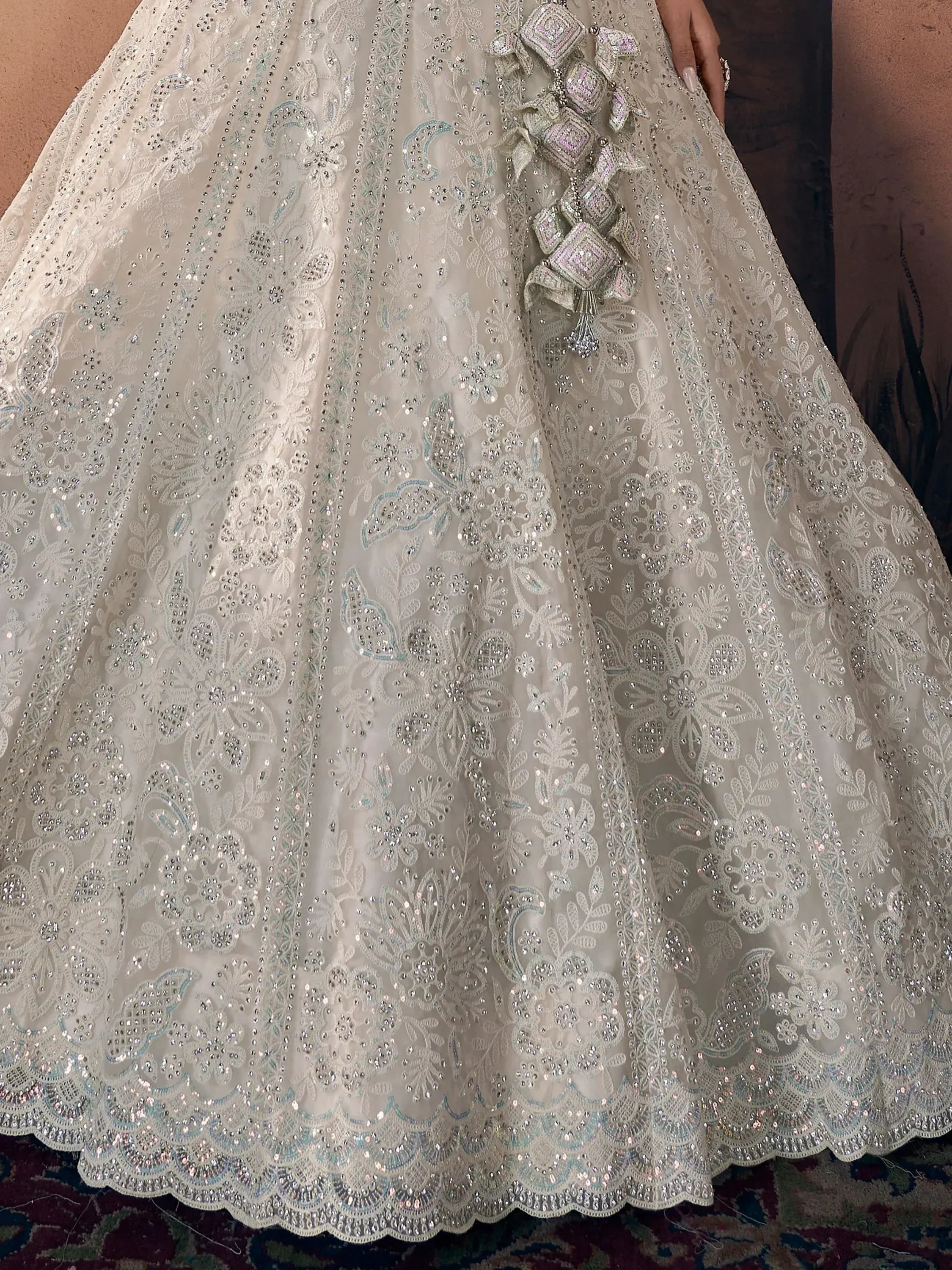 Elegant white lehenga with intricate floral embroidery and sequin detailing, perfect for Indian weddings and festive occasions.