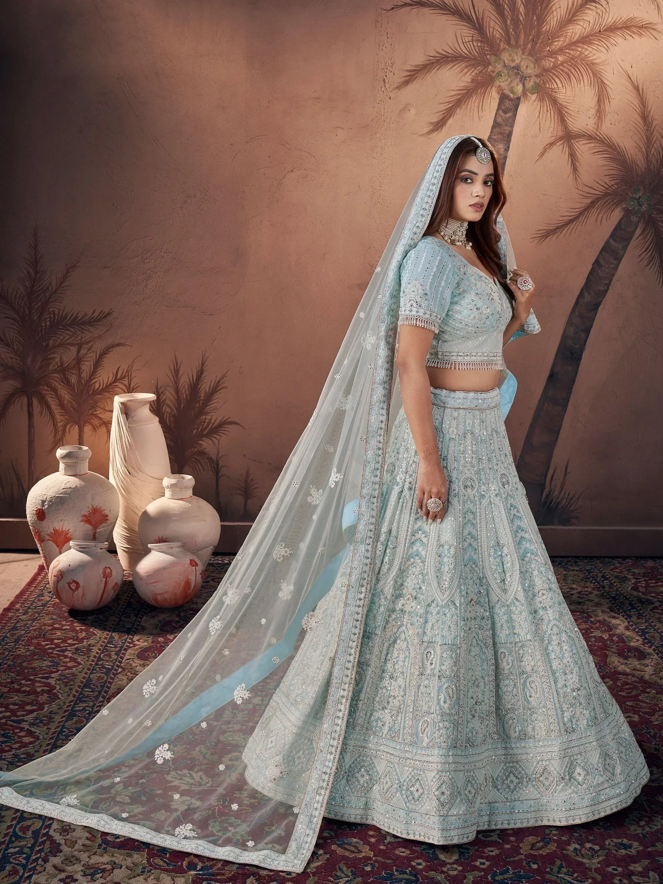 Light blue designer lehenga choli with intricate embroidery, perfect for weddings and festive occasions.