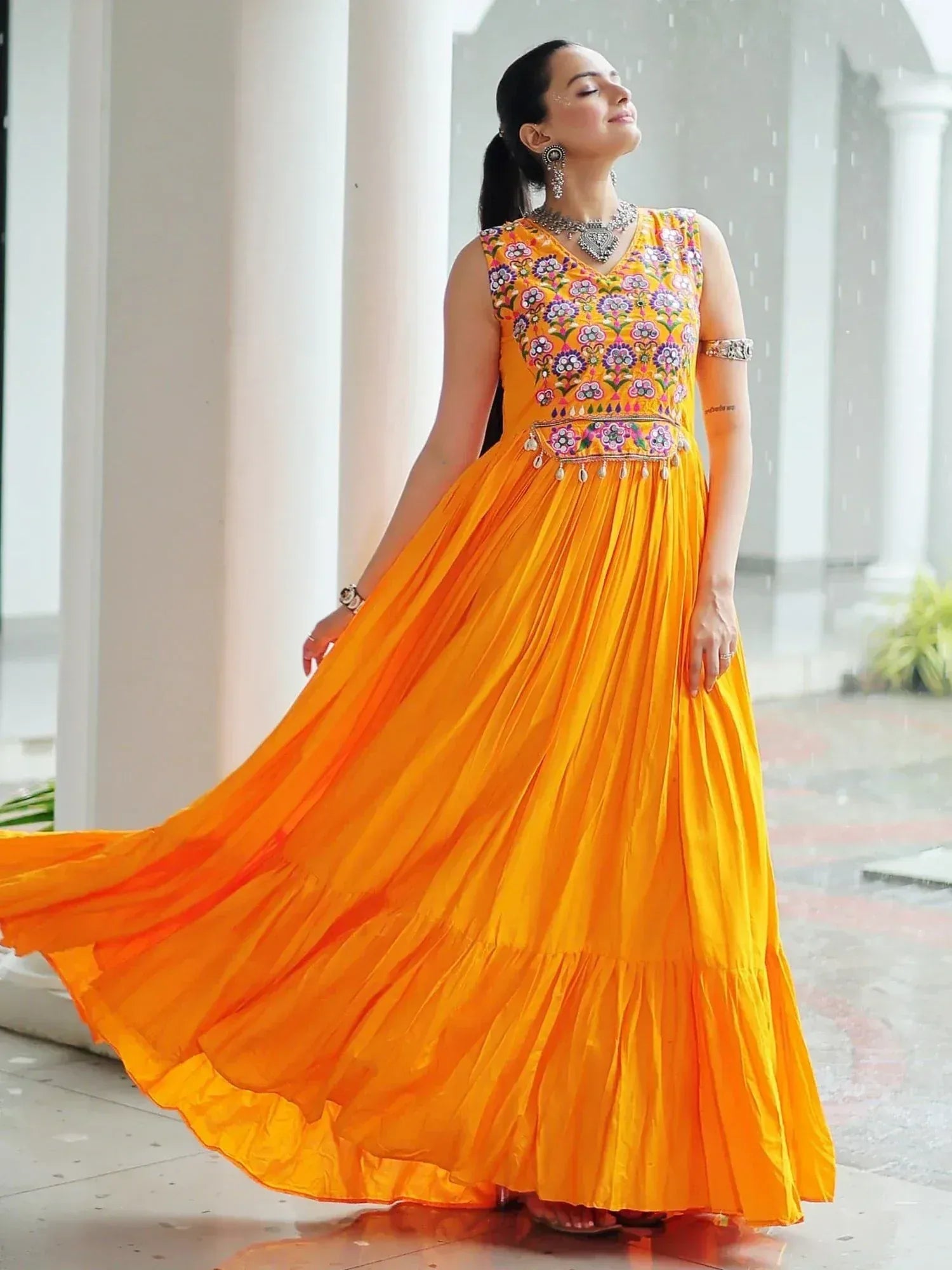Vibrant orange ethnic gown with floral embroidery, perfect for Indian celebrations and festive occasions.
