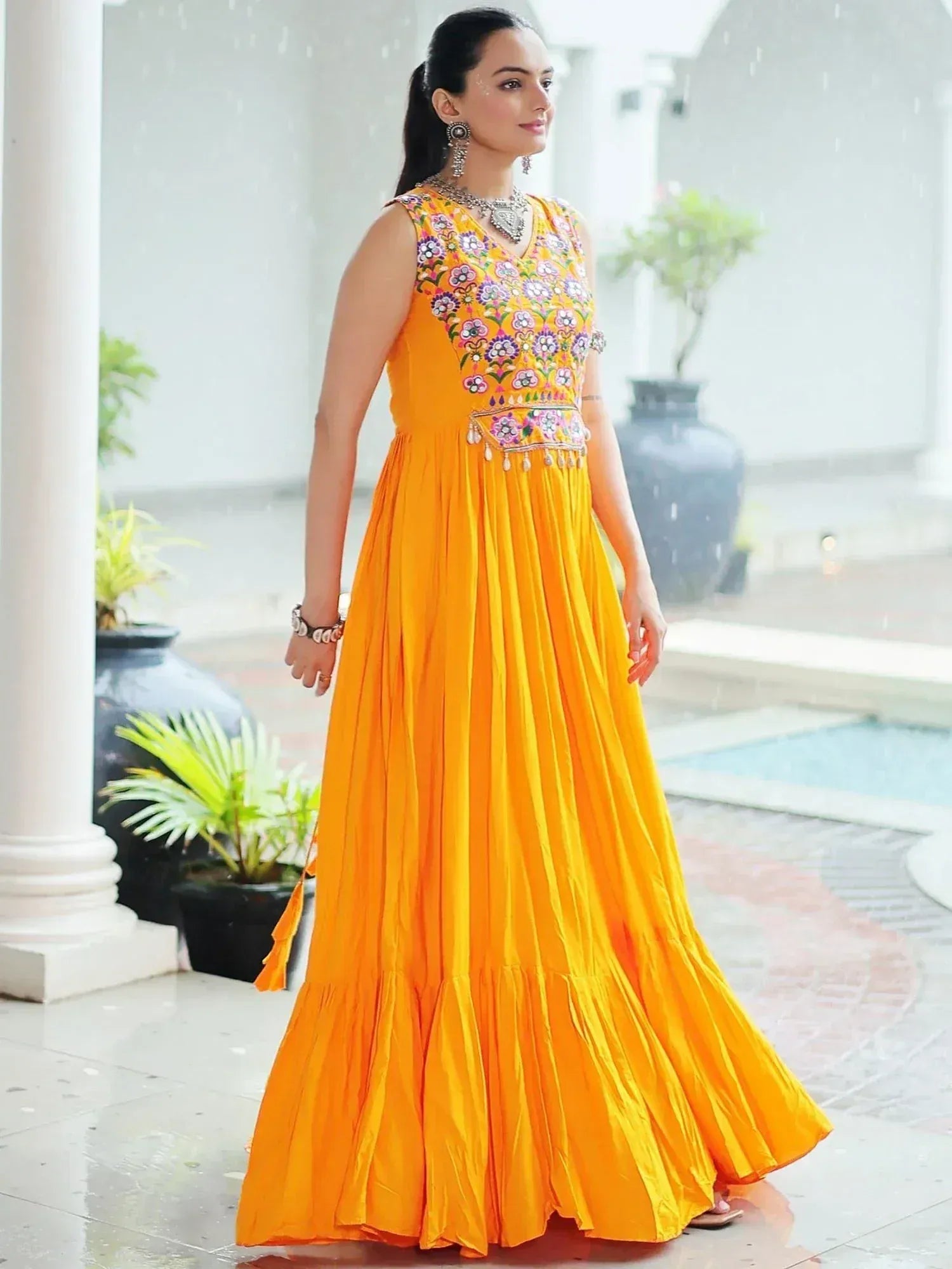 Vibrant orange ethnic gown with floral embroidery, perfect for Indian festive occasions.
