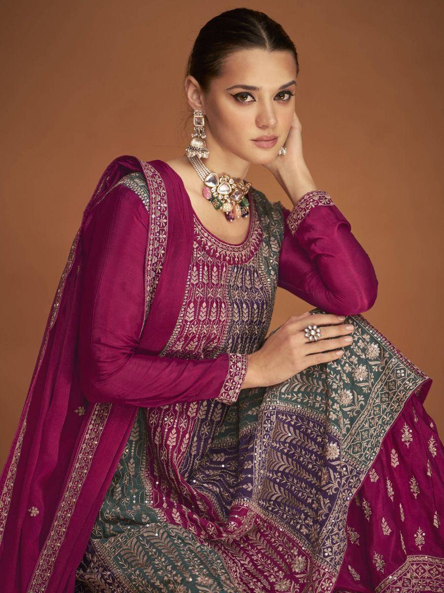 Elegant maroon and green embroidered salwar kameez with traditional jewelry, perfect for festive occasions.