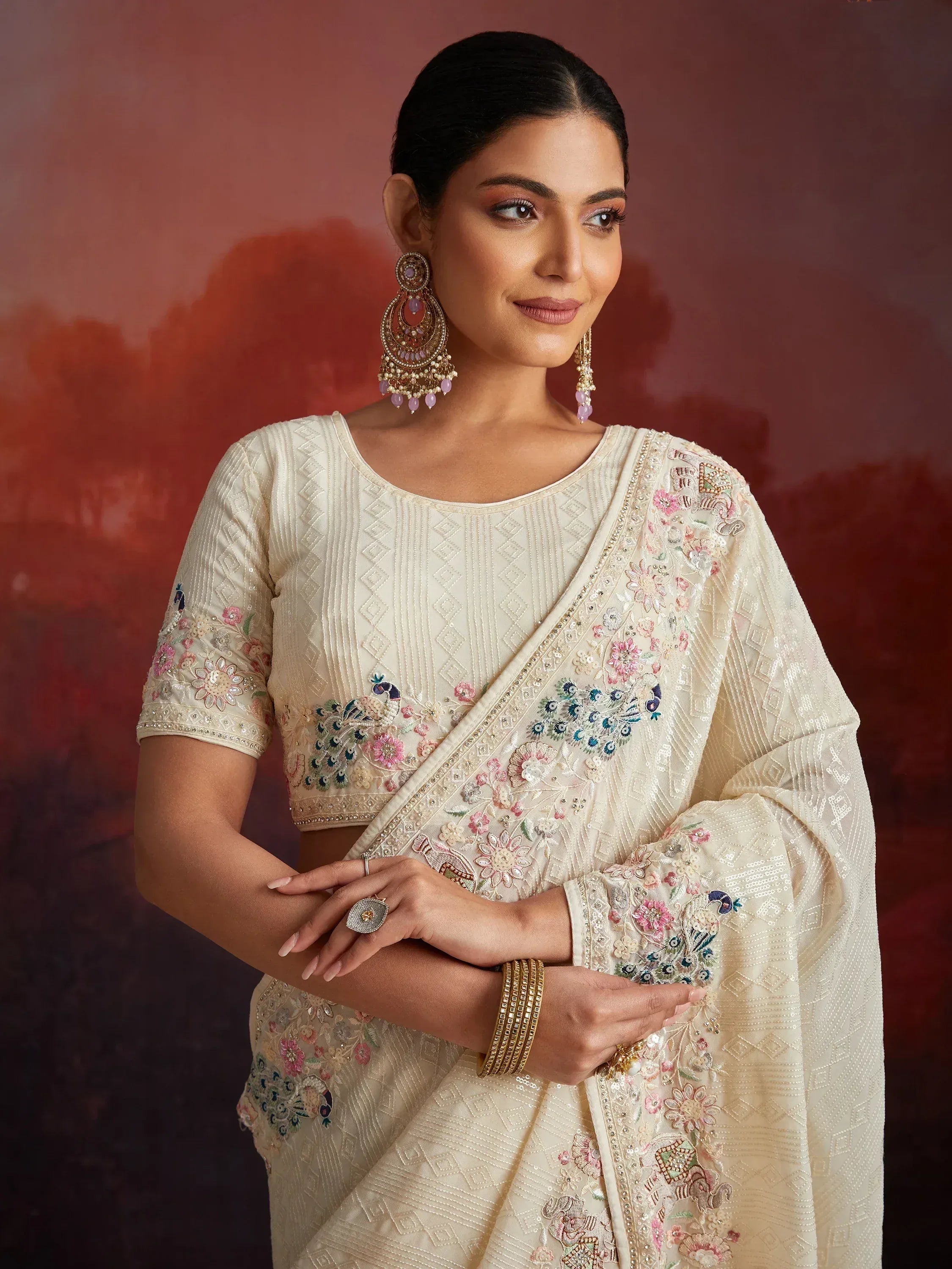 Elegant cream saree with floral and peacock embroidery, perfect for Indian ethnic occasions.