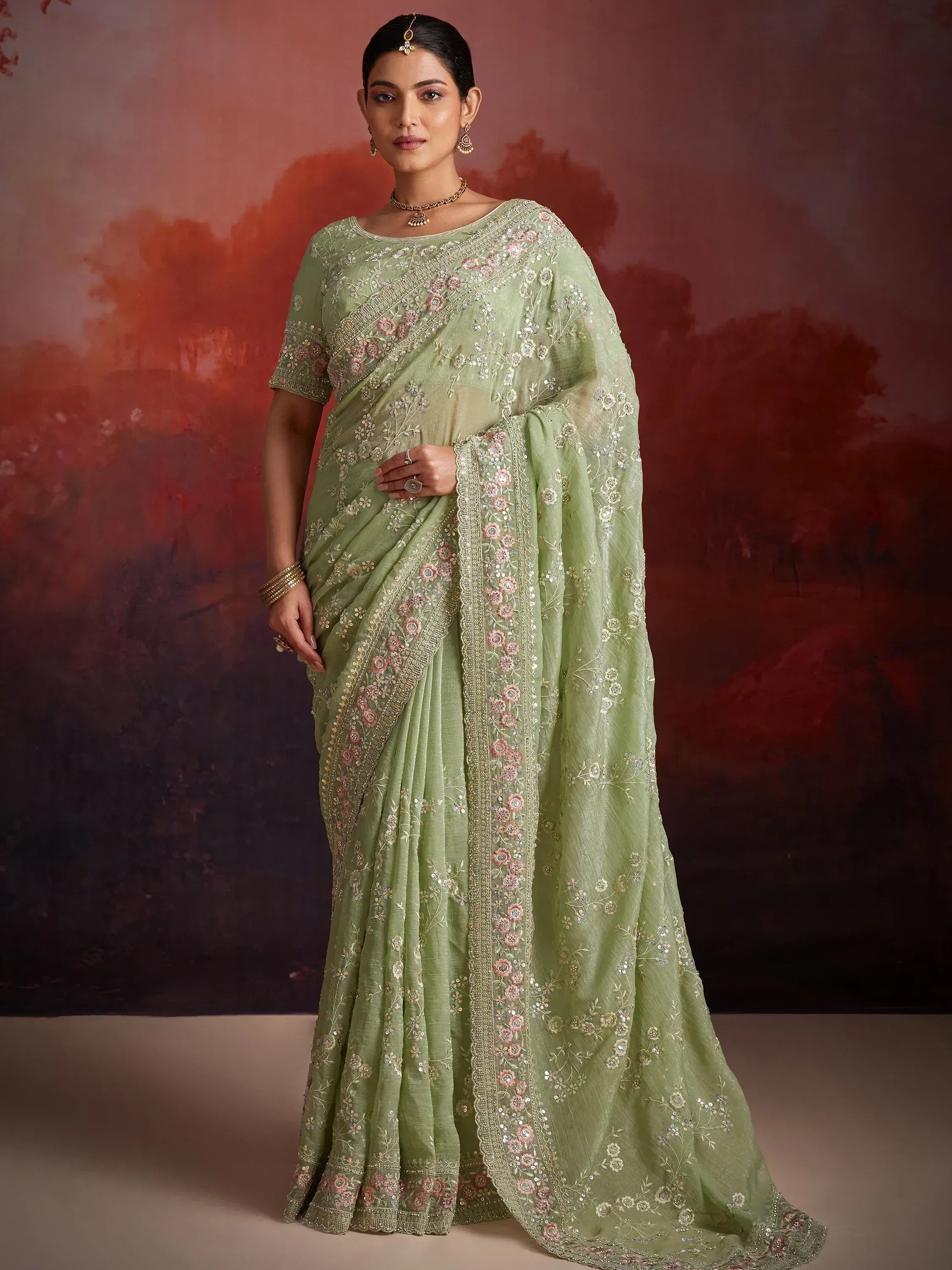 Mint green embroidered saree with floral motifs and gold detailing, perfect for Indian ethnic occasions.