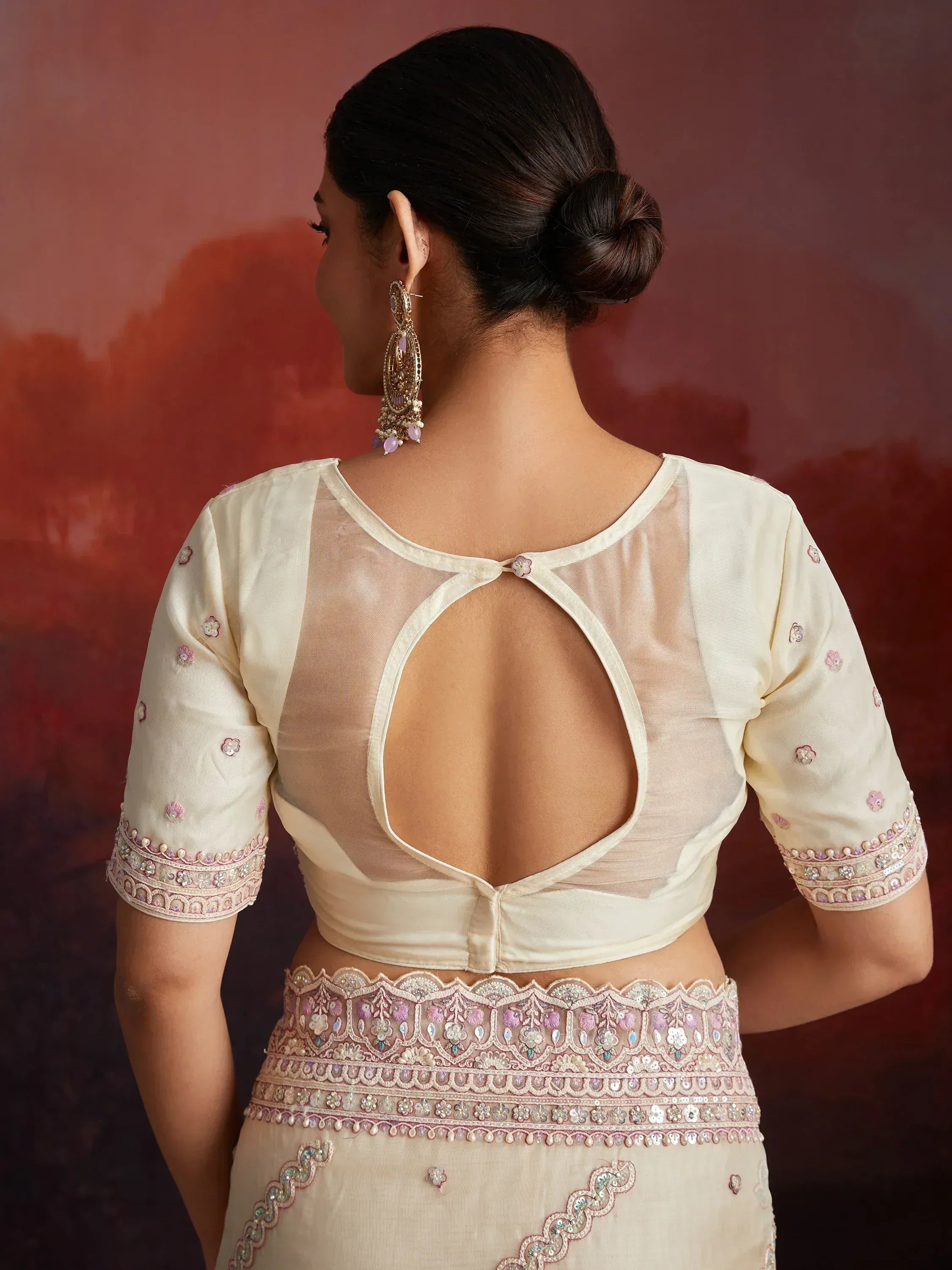 Cream lehenga choli with sheer back blouse, floral embroidery, and embellished waistband for Indian ethnic wear