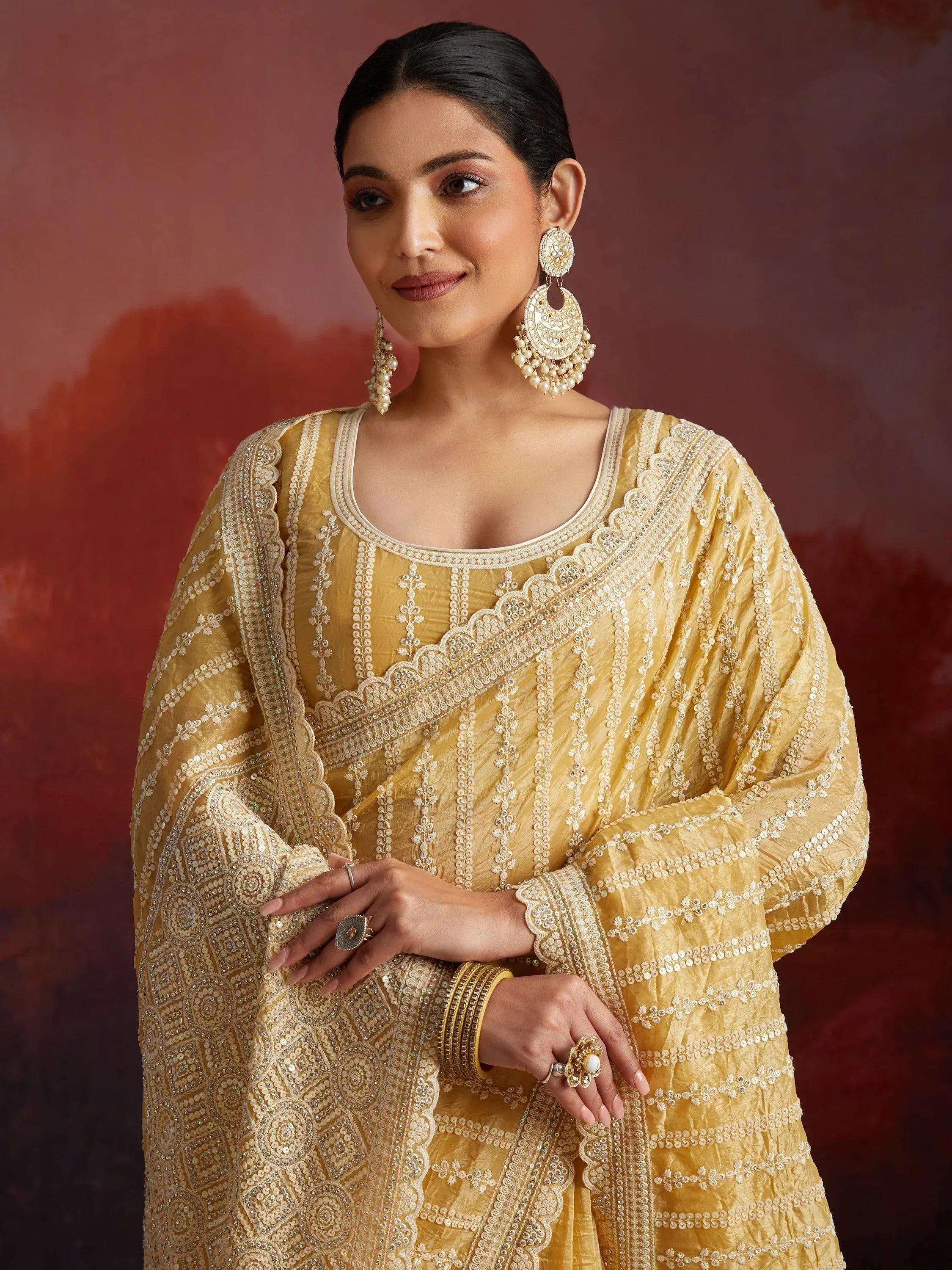 Elegant yellow embroidered salwar kameez with pearl jewelry, perfect for Indian ethnic occasions