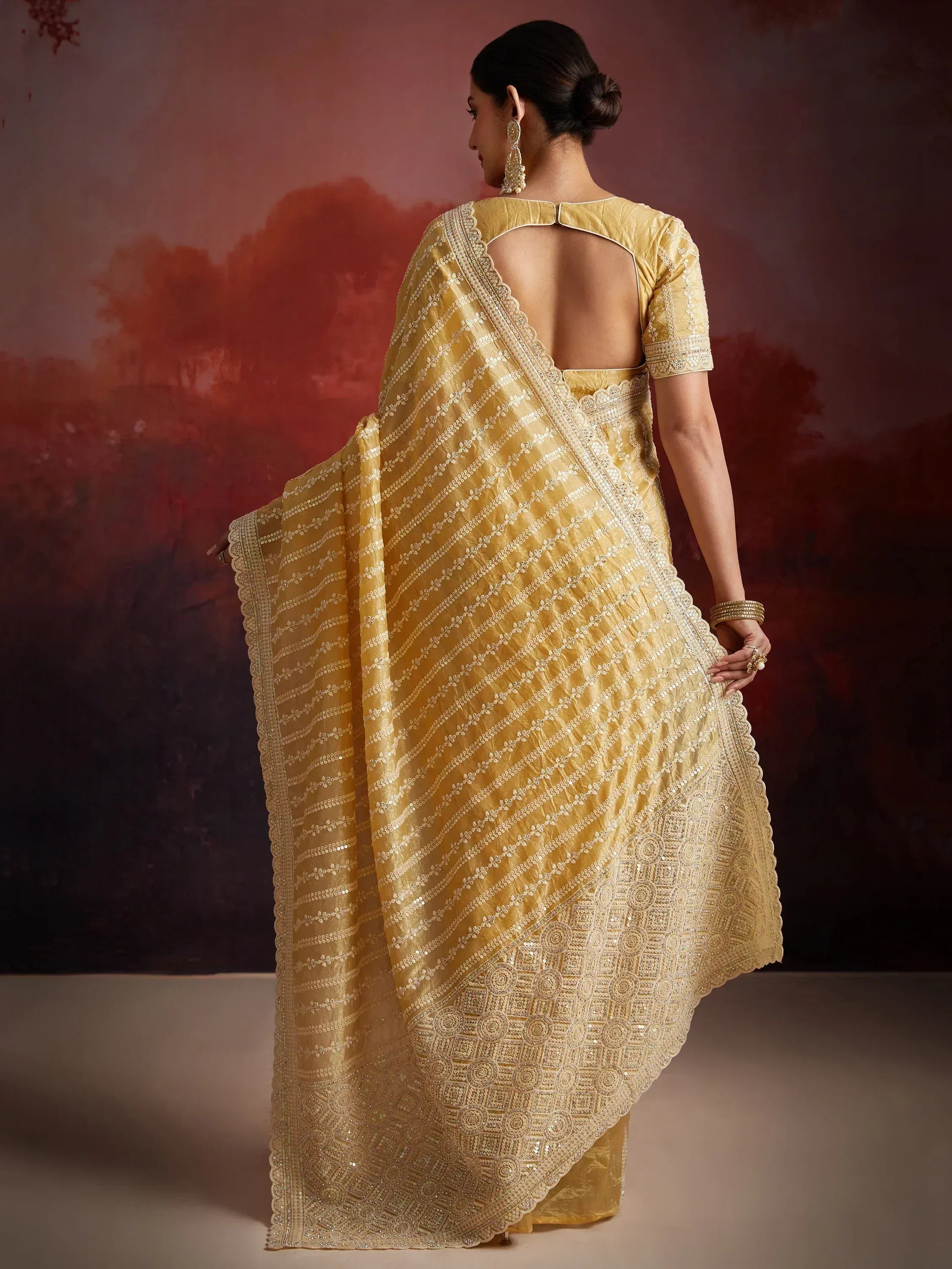 Elegant yellow designer saree with intricate embroidery and scalloped border, perfect for Indian ethnic occasions.