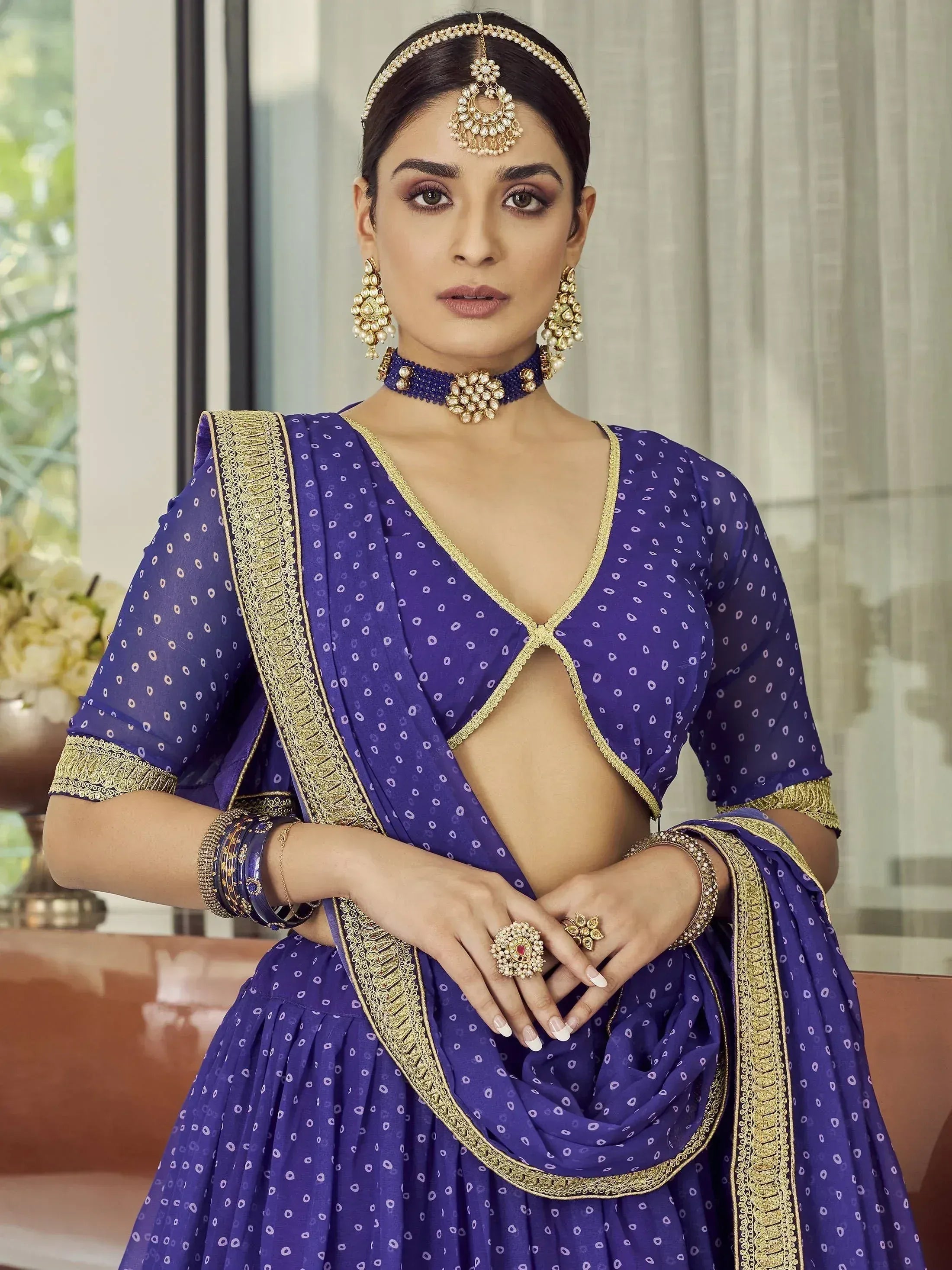 Royal blue designer lehenga choli with gold embroidery and traditional Indian jewelry for weddings