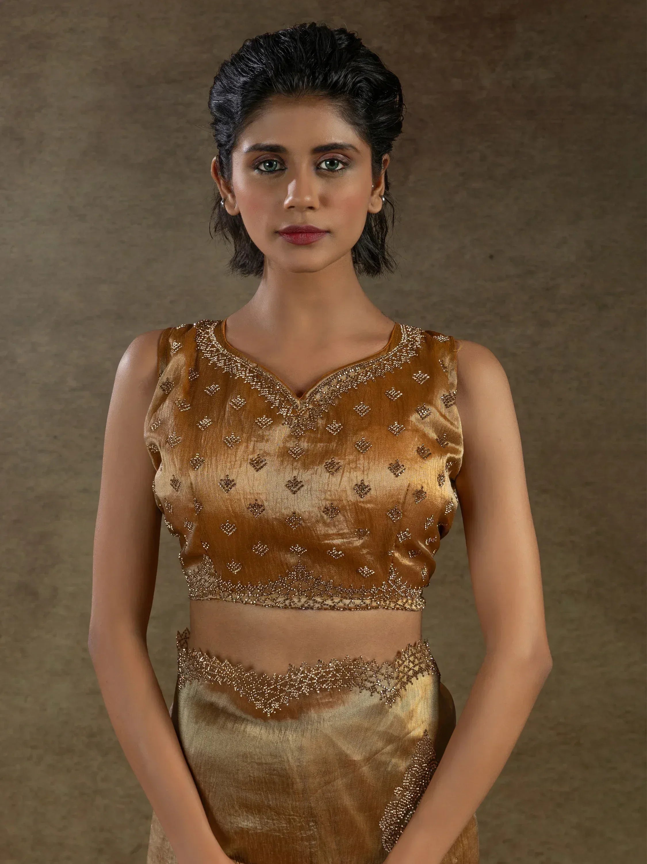 Golden embroidered lehenga choli with intricate beadwork and sleeveless blouse design