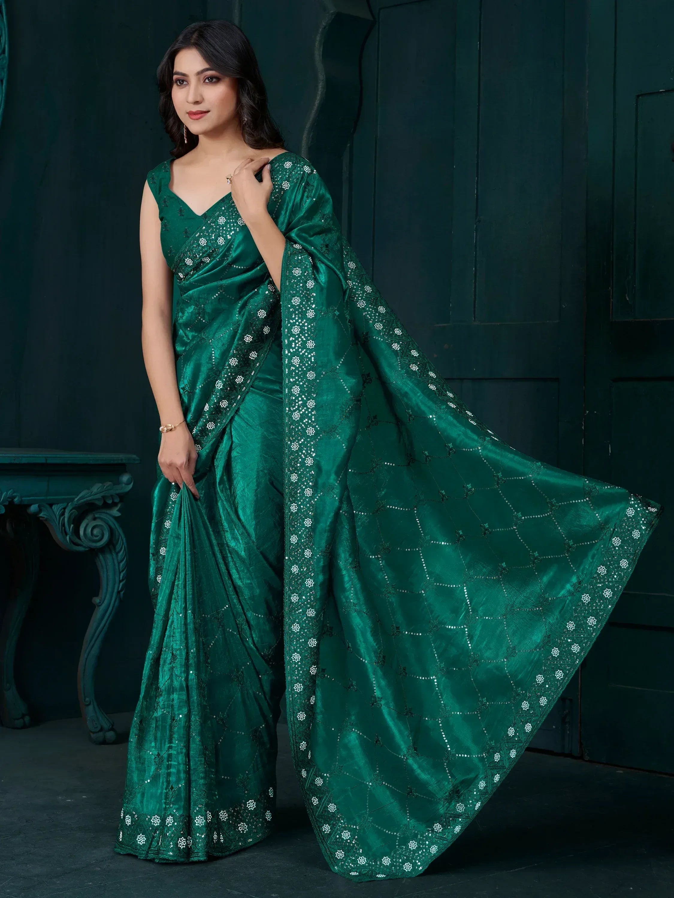 Emerald green designer saree with intricate embroidery and sequin detailing, perfect for ethnic occasions.