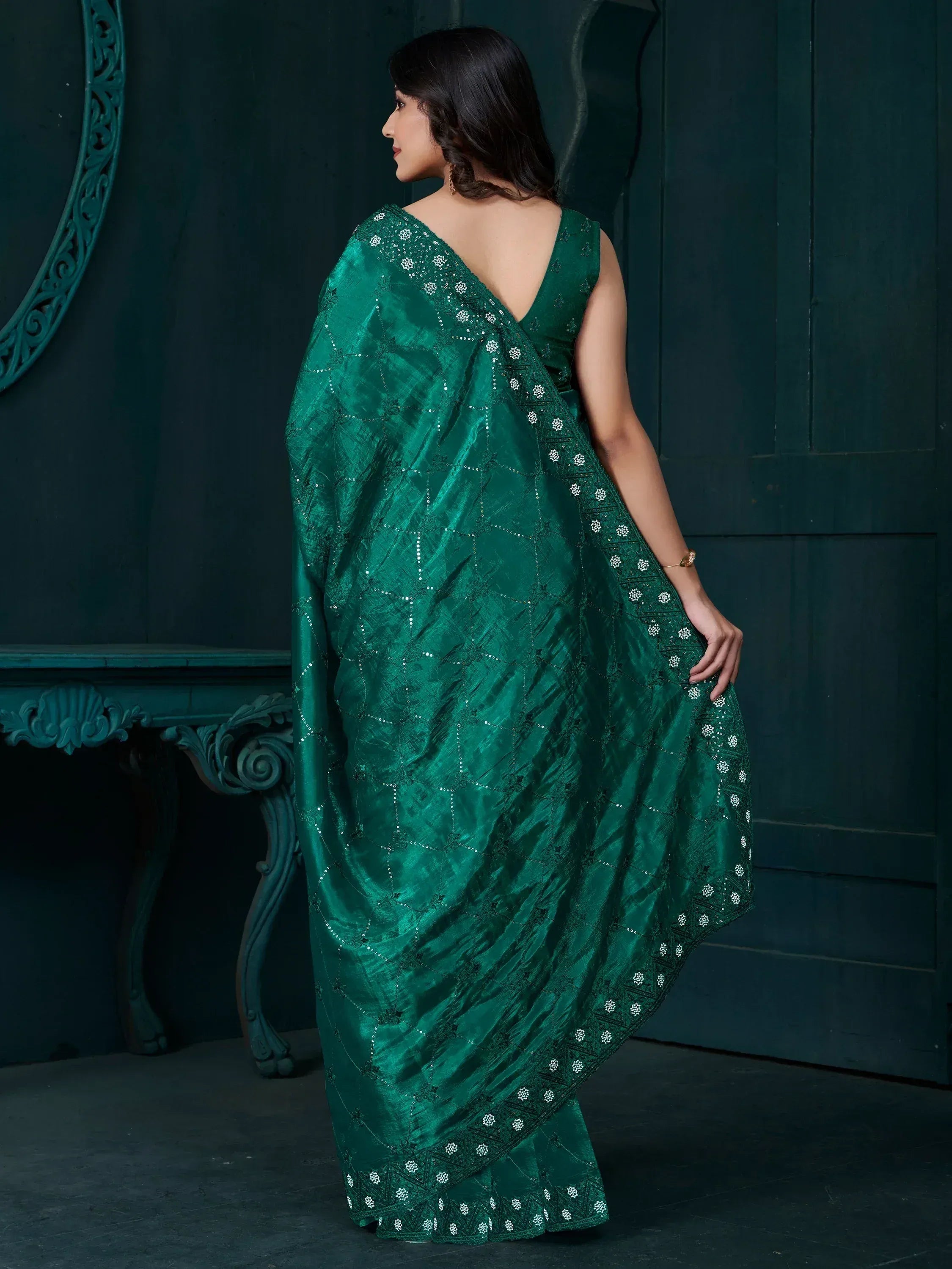 Emerald green embroidered saree with floral motifs and sequin detailing, perfect for ethnic occasions.