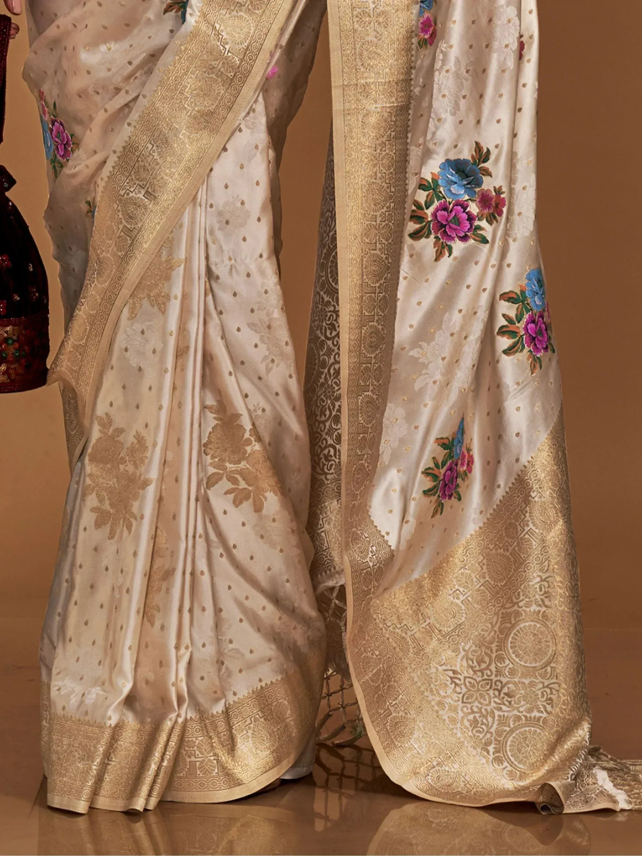 Cream saree with gold zari border and colorful floral embroidery, ideal for Indian ethnic wear