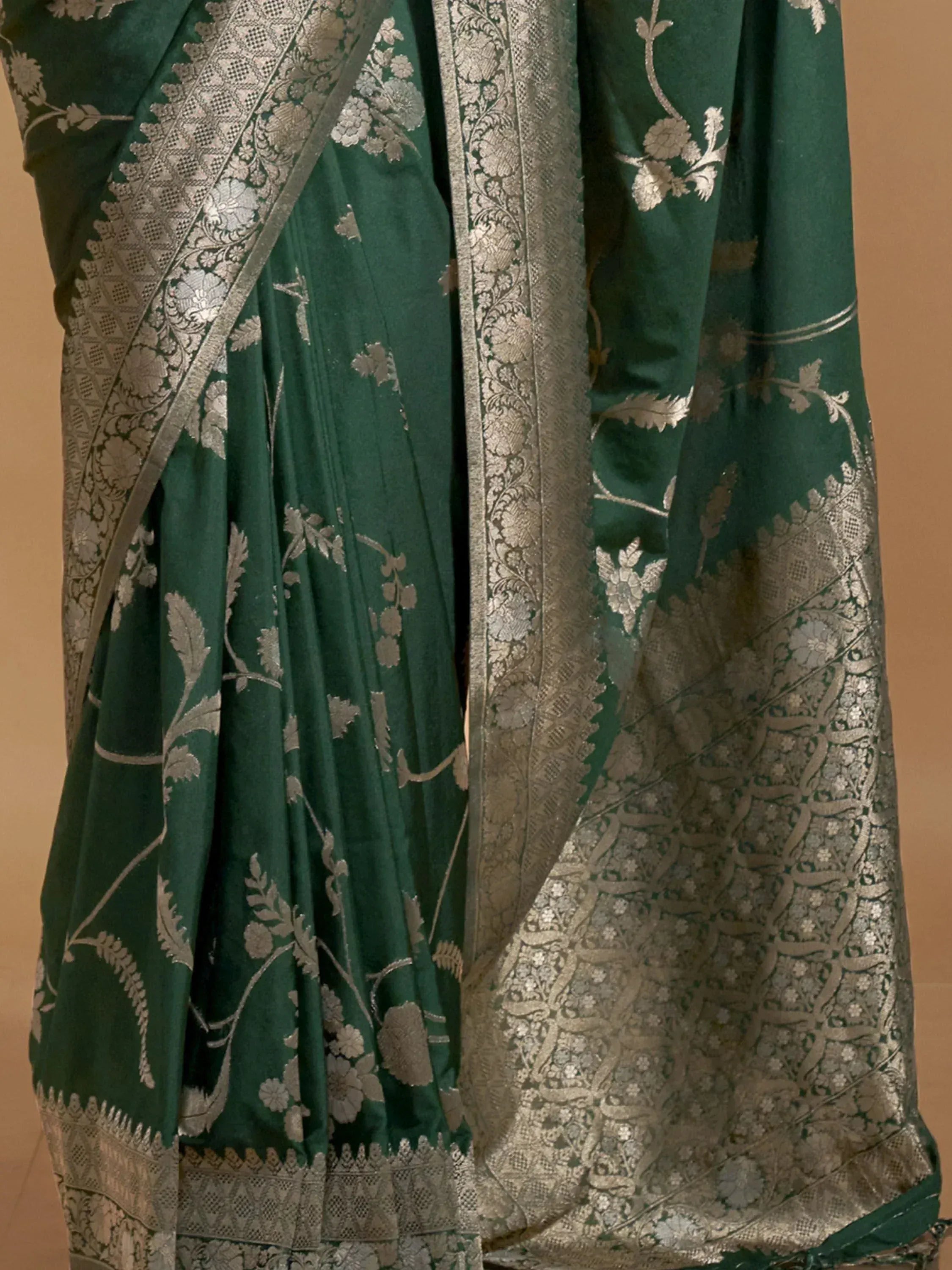 Emerald green designer saree with silver floral zari work and intricate border, perfect for ethnic occasions.