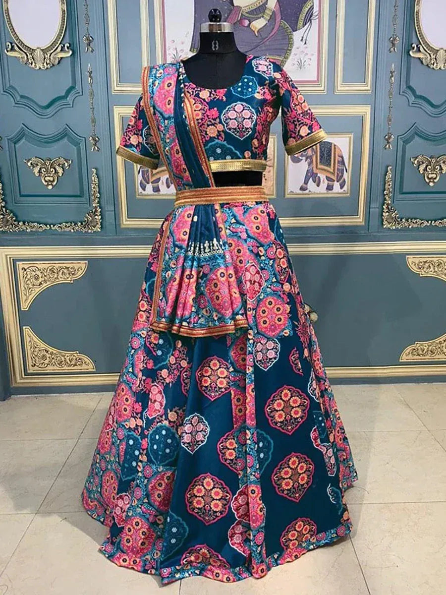 Blue and pink floral print lehenga choli with gold trim, displayed on mannequin against ornate wall