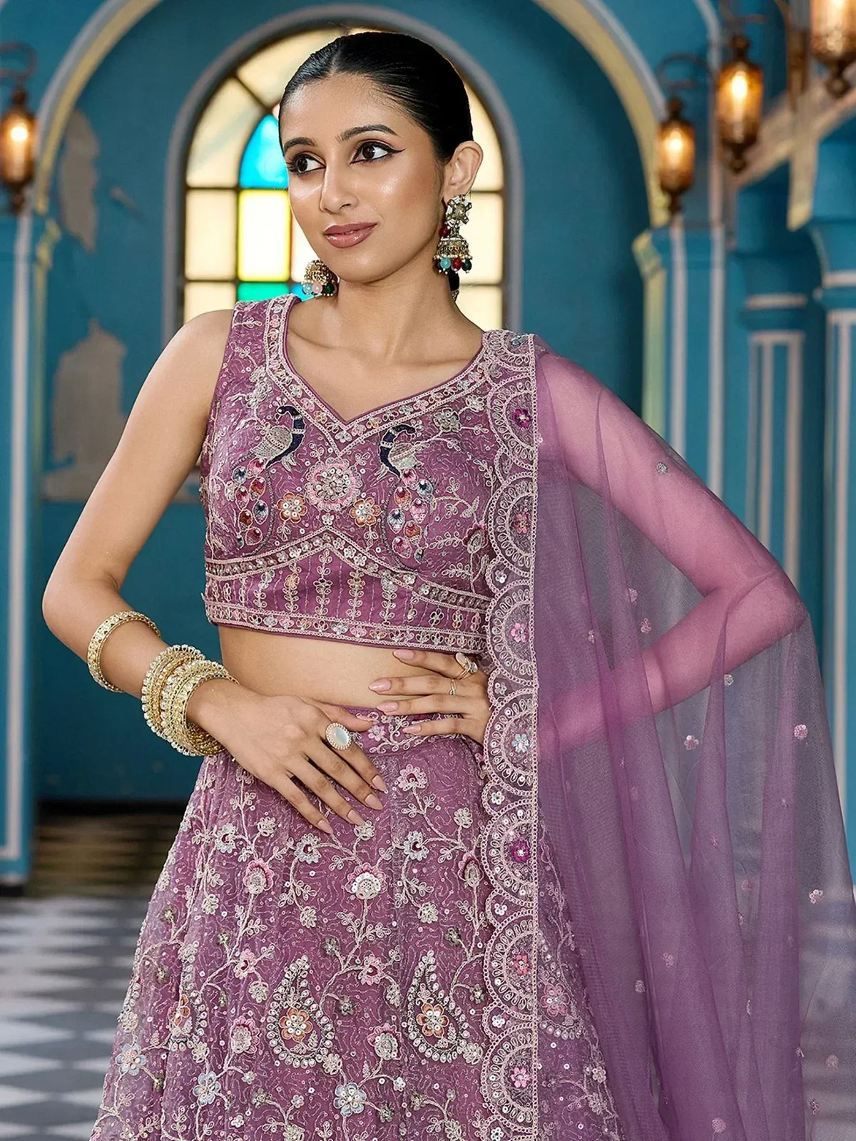 Elegant purple embroidered lehenga choli with floral and peacock motifs, paired with sheer dupatta
