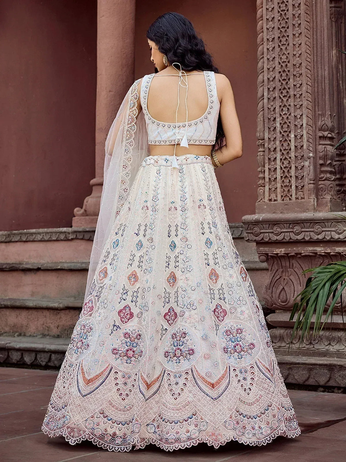 Elegant white lehenga choli with intricate floral embroidery and lace detailing, perfect for Indian ethnic wear.