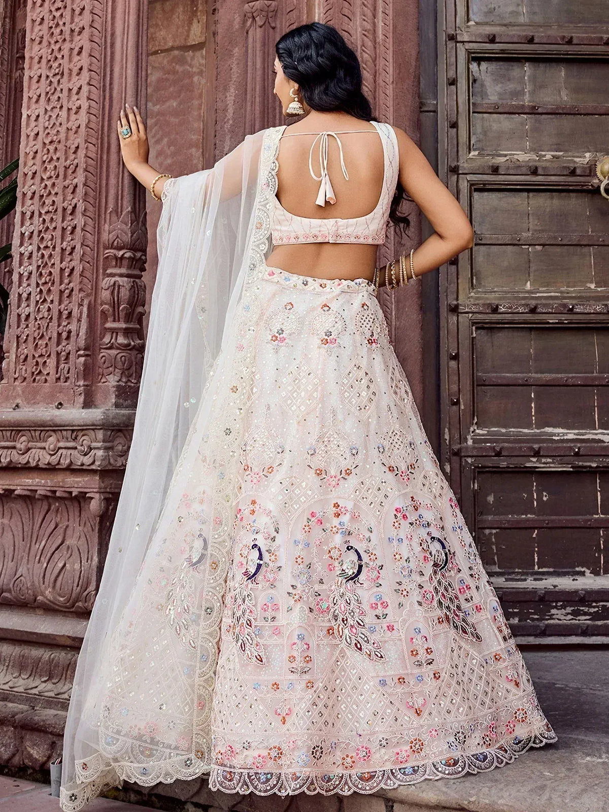 Elegant white lehenga choli with peacock embroidery and floral motifs, perfect for Indian ethnic wear.