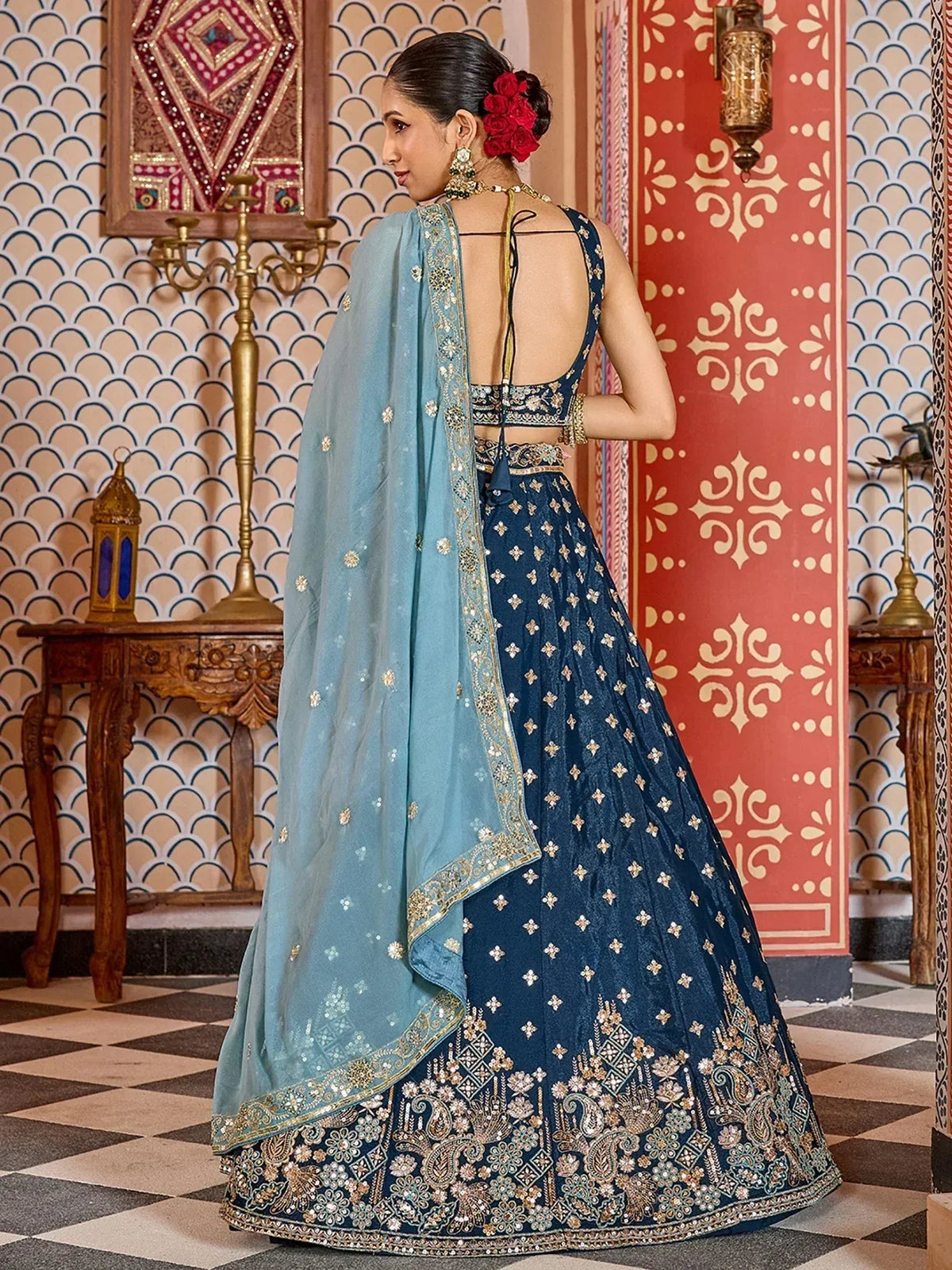 Elegant navy blue lehenga choli with gold embroidery and light blue dupatta, perfect for Indian ethnic wear.