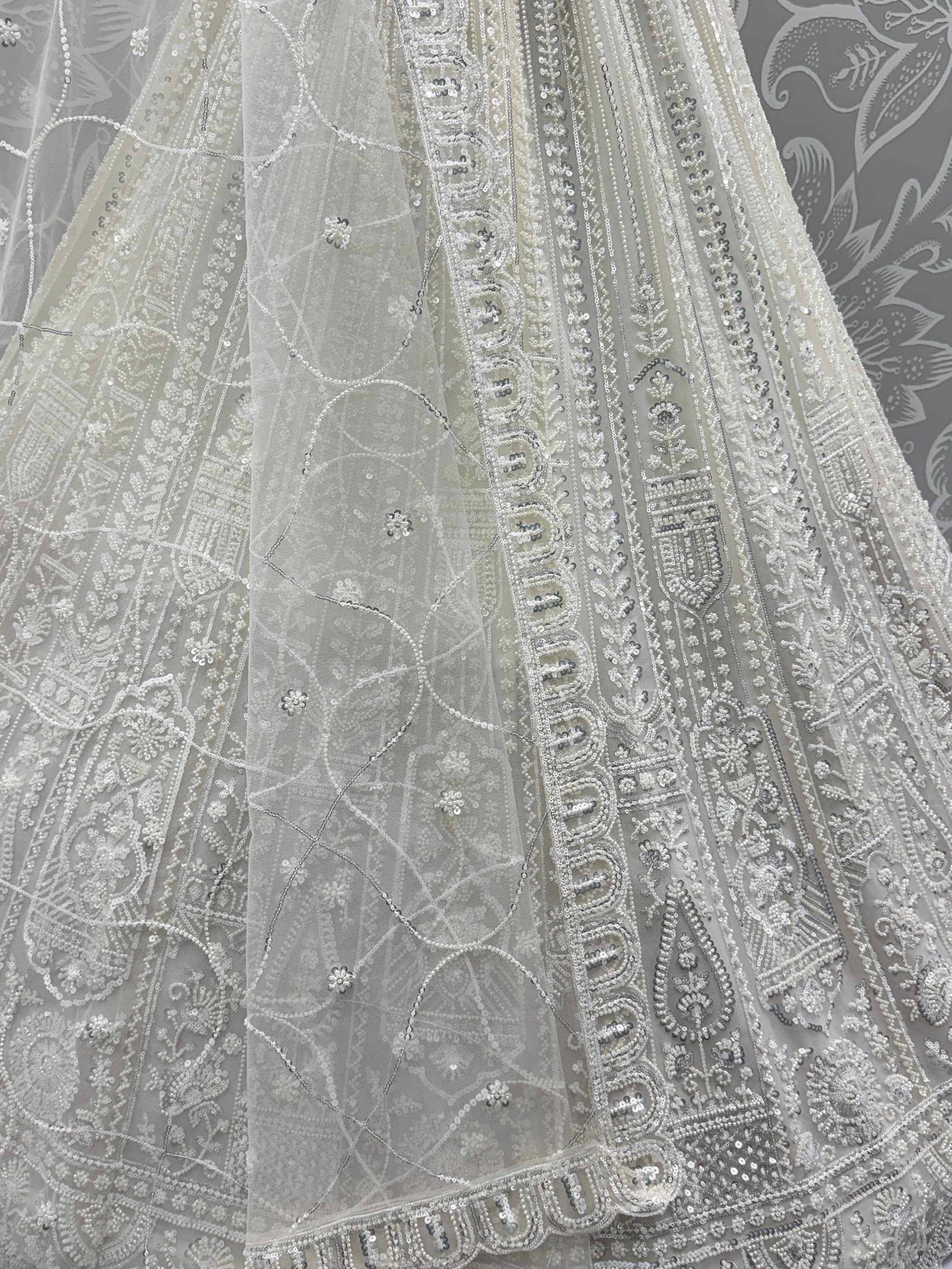 Elegant white lehenga with intricate silver bead and sequin embroidery, perfect for Indian ethnic wear.