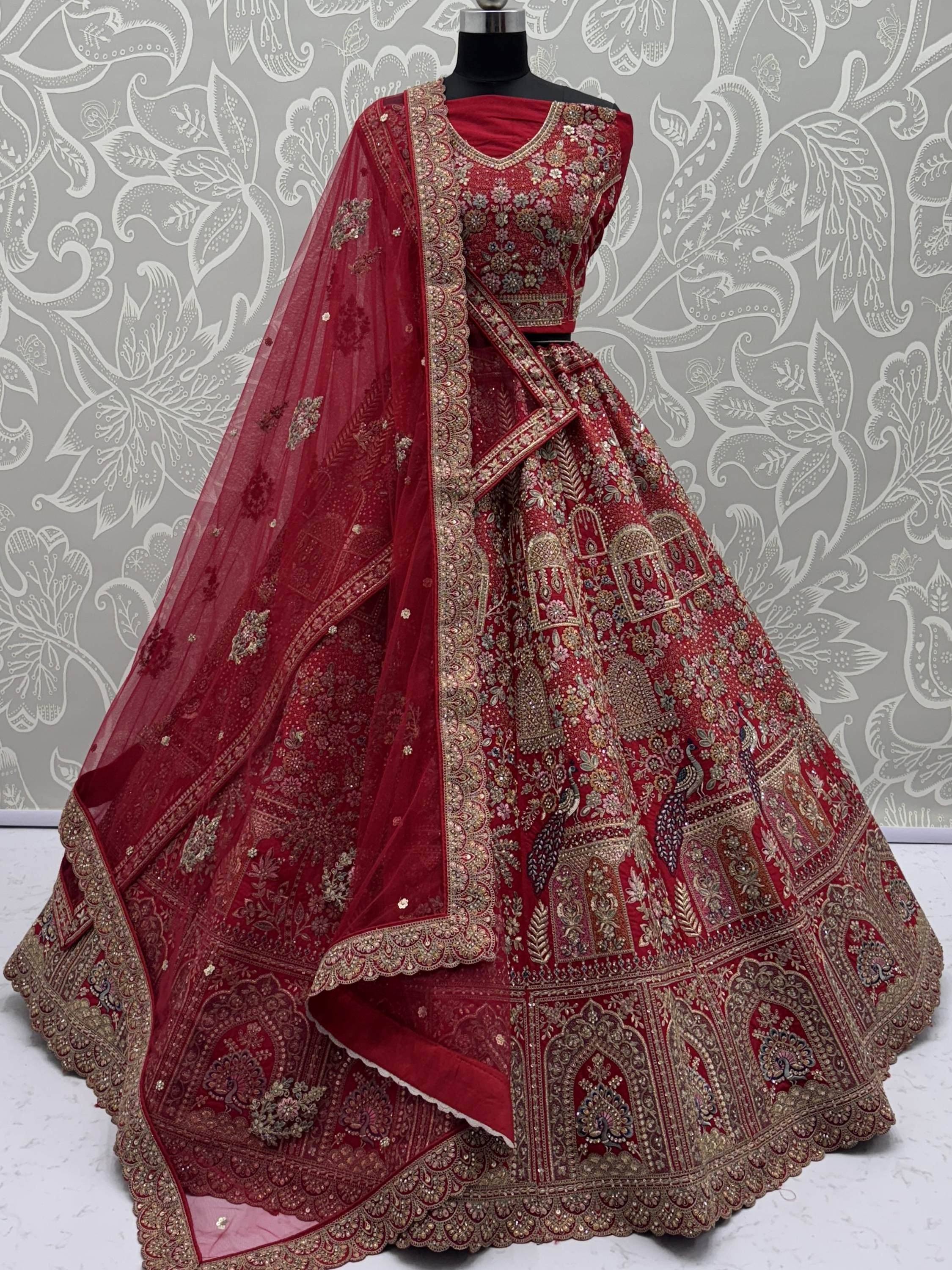 Red embroidered lehenga choli with peacock motifs and gold detailing, perfect for Indian weddings and festive occasions.
