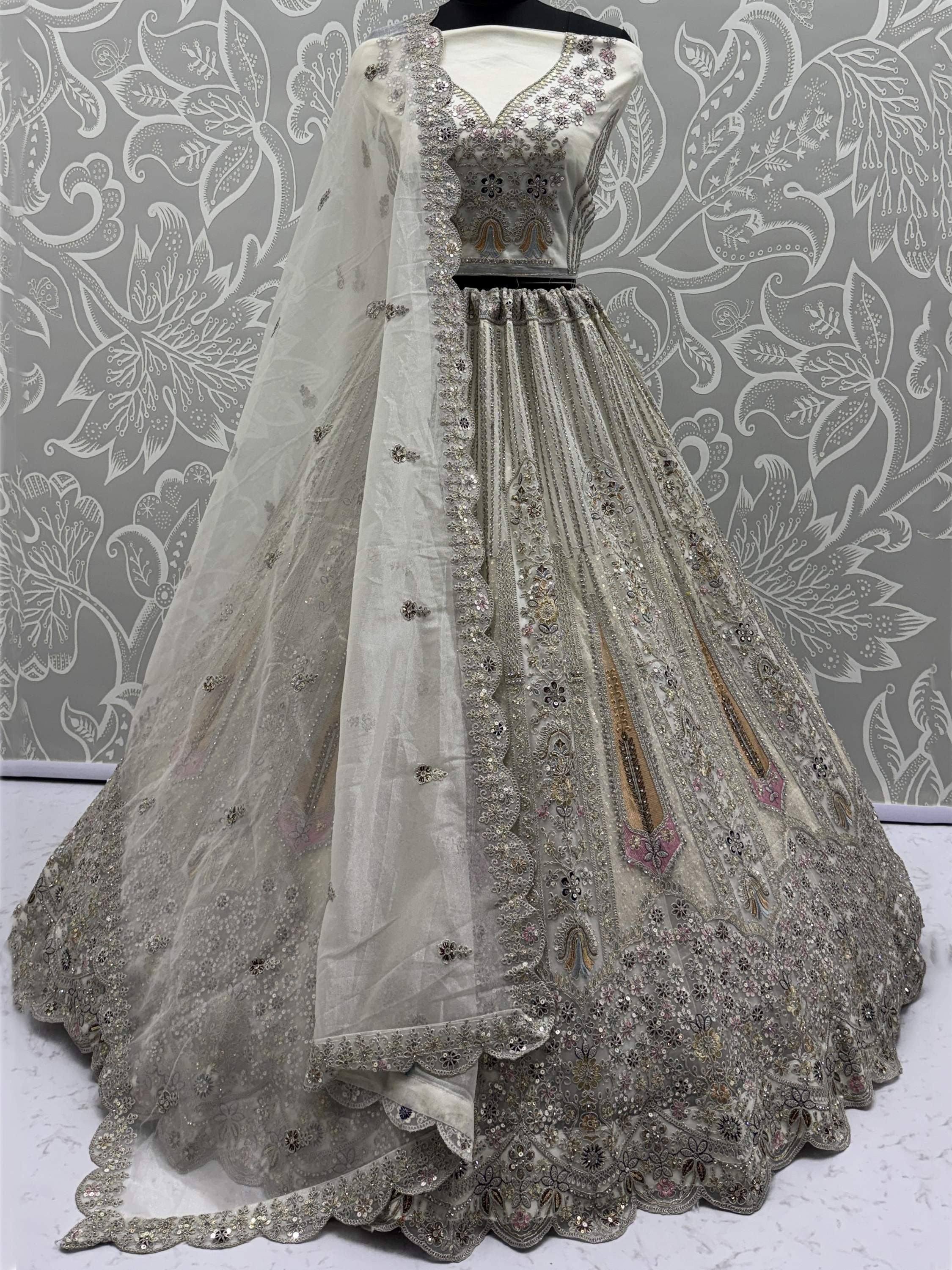 Elegant silver embroidered lehenga choli with sheer dupatta, perfect for Indian weddings and festive occasions.