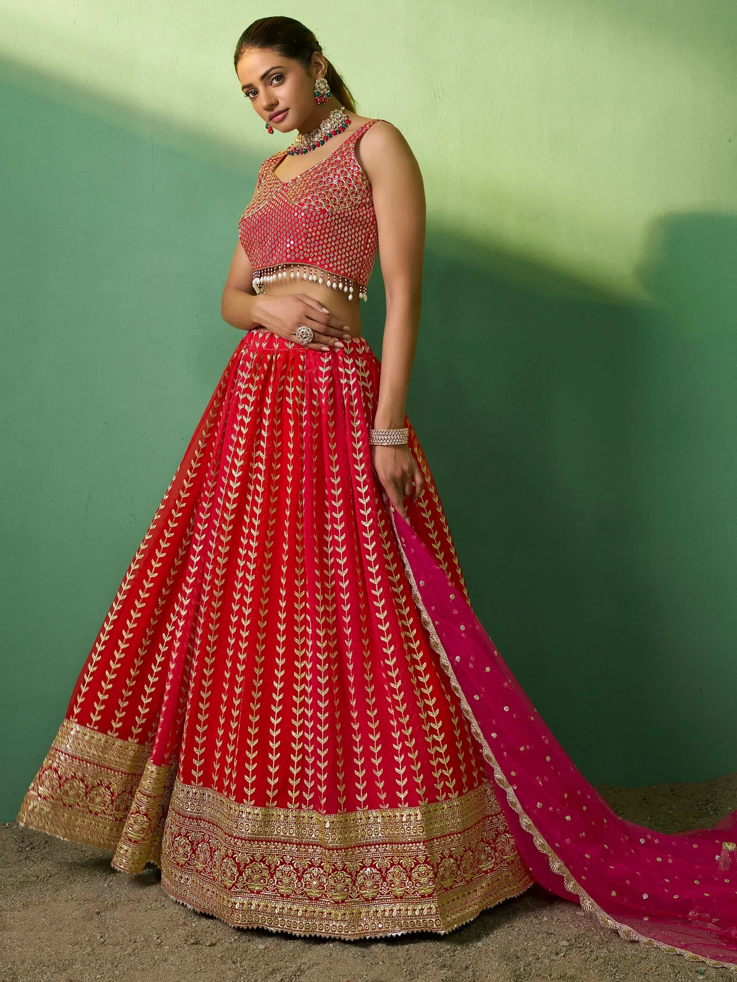 Red and gold embroidered lehenga choli with intricate detailing and matching dupatta