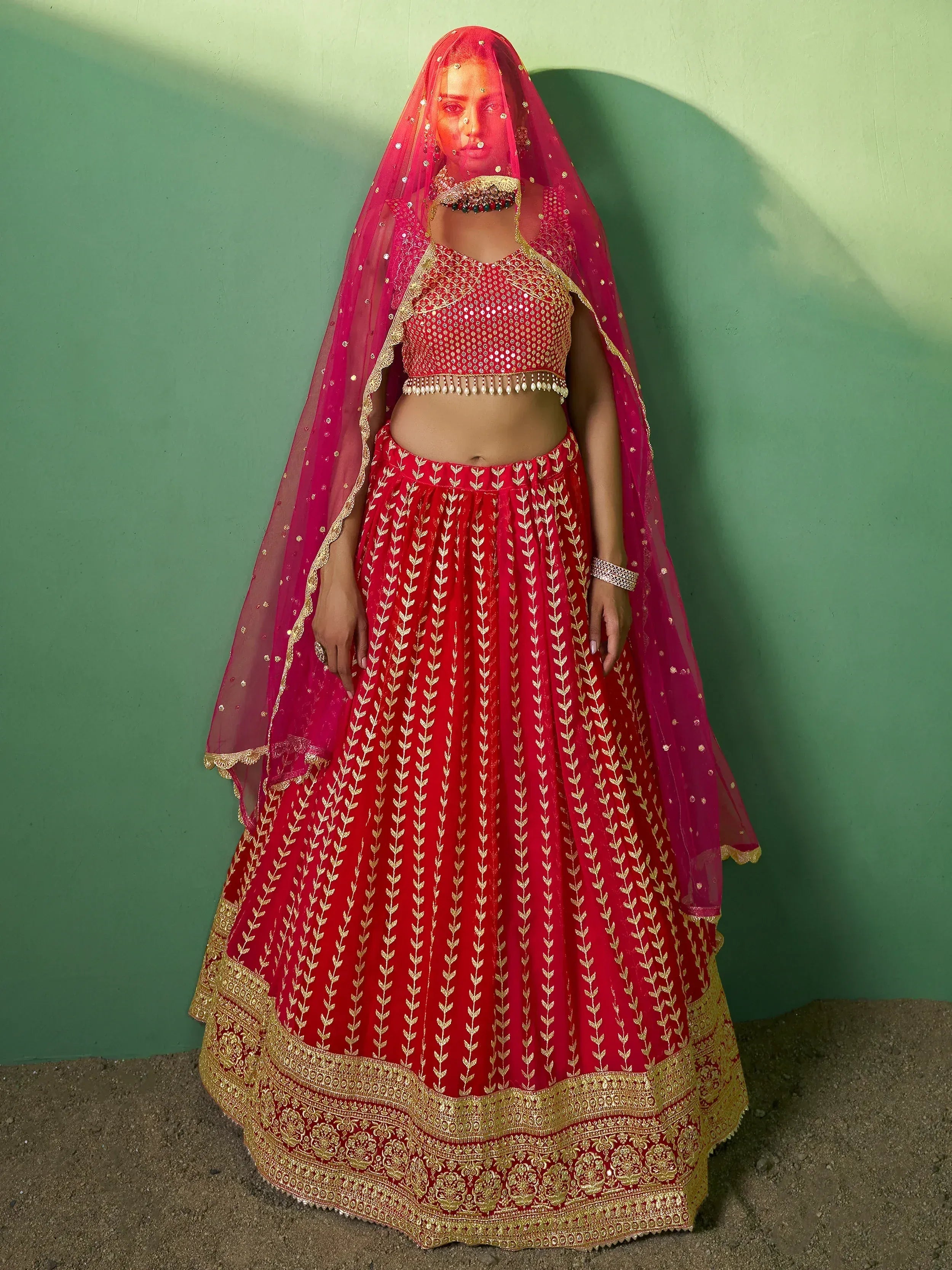 Red and gold embroidered lehenga choli with matching dupatta, perfect for Indian weddings and festive occasions.
