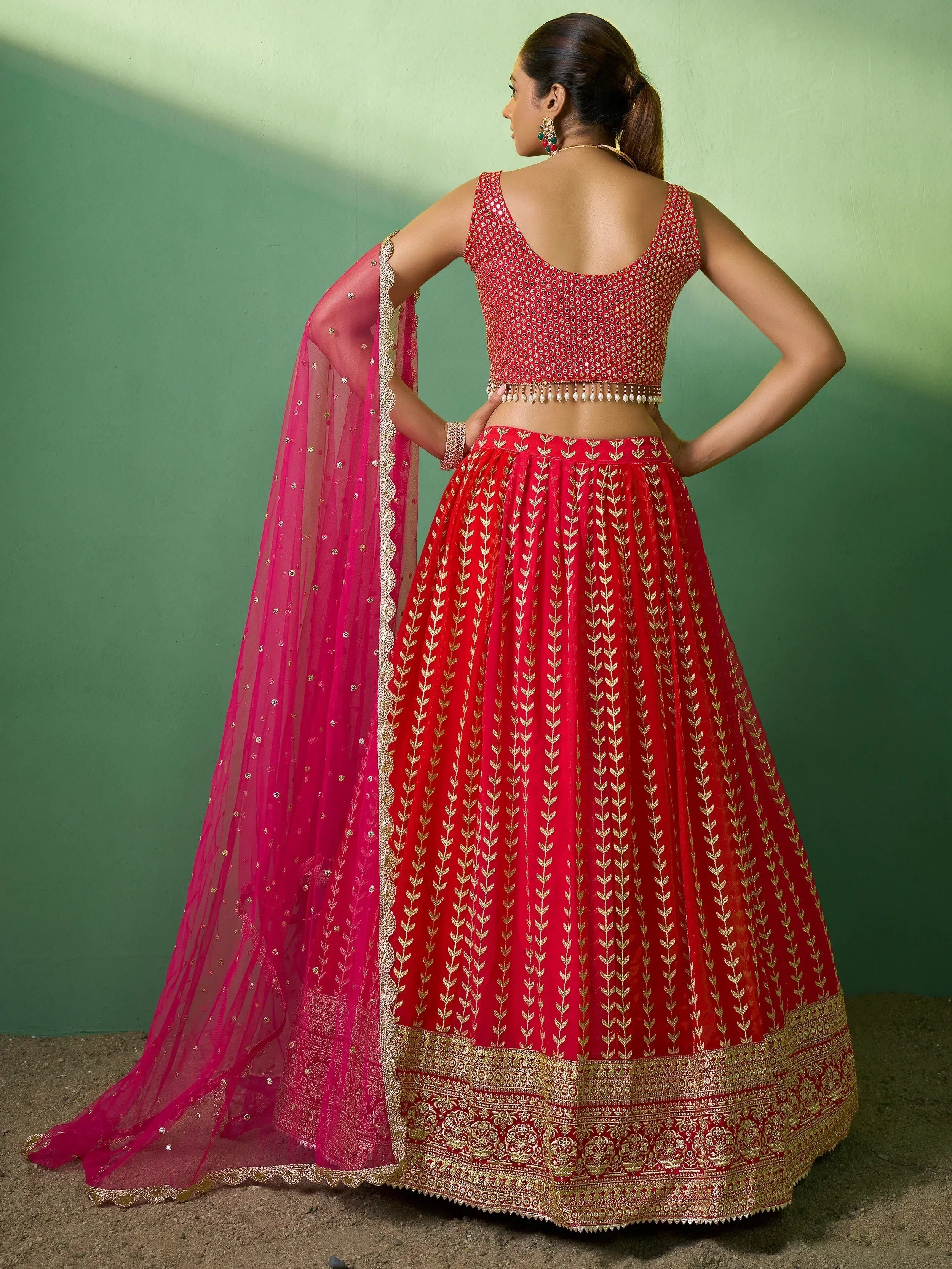 Red embroidered lehenga choli with gold detailing and pink dupatta for Indian ethnic wear