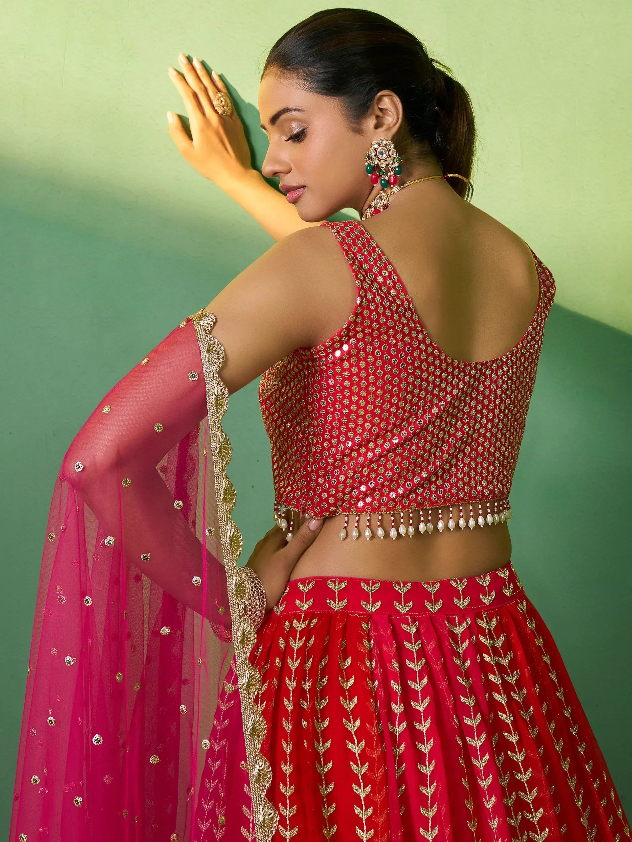 Red embroidered lehenga choli with gold detailing and pink dupatta for Indian ethnic wear