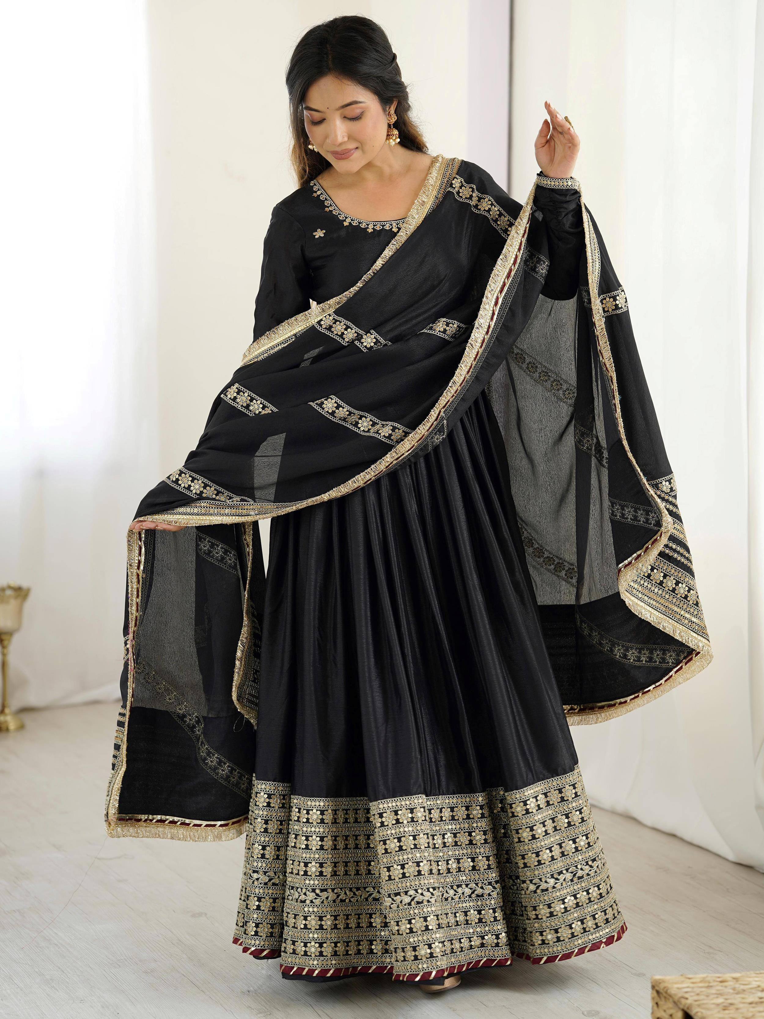 Black ethnic lehenga choli with gold embroidery and sheer dupatta, perfect for Indian weddings or festive occasions.