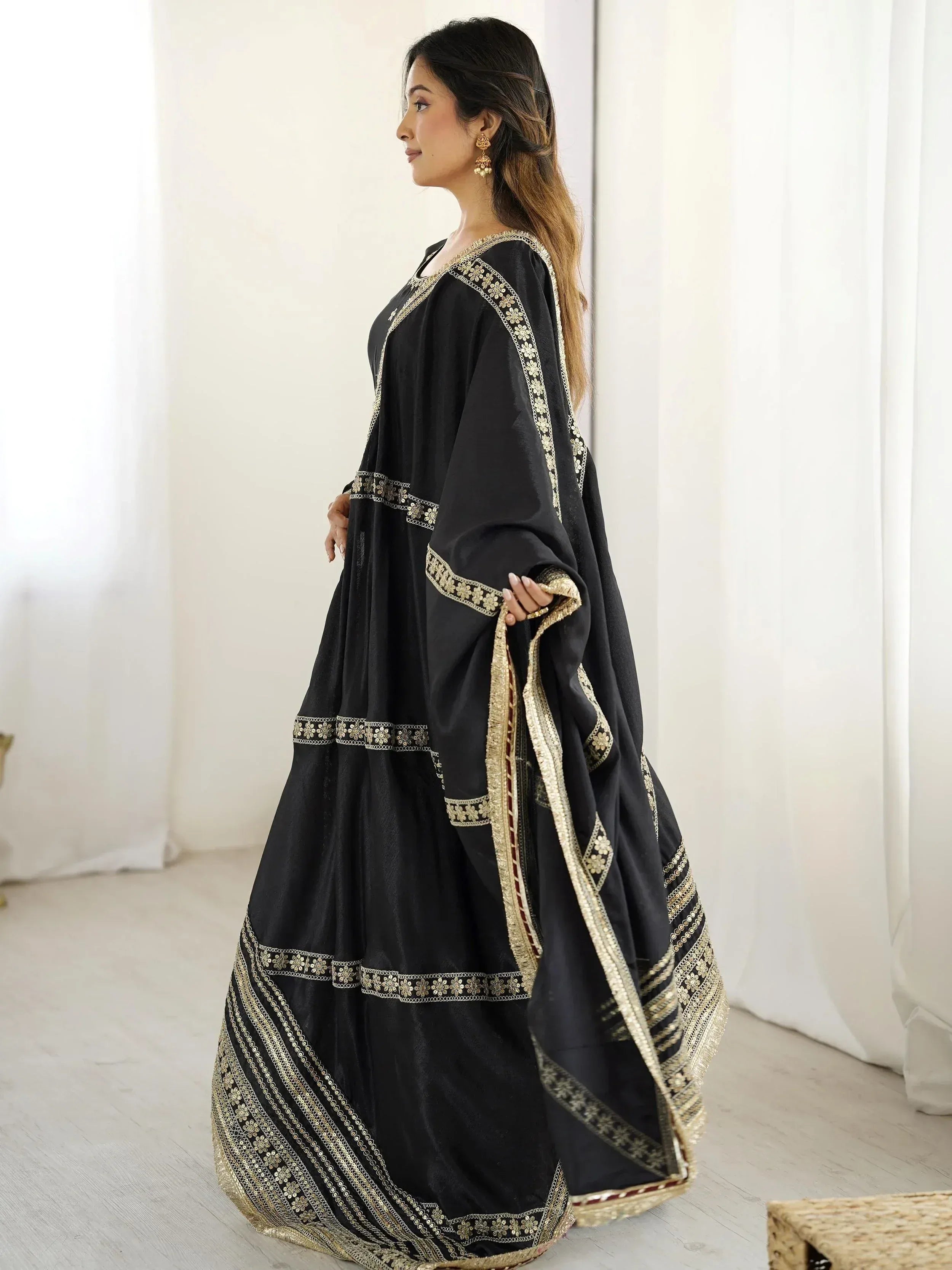 Black ethnic gown with gold embroidery, perfect for Indian festive wear and special occasions.