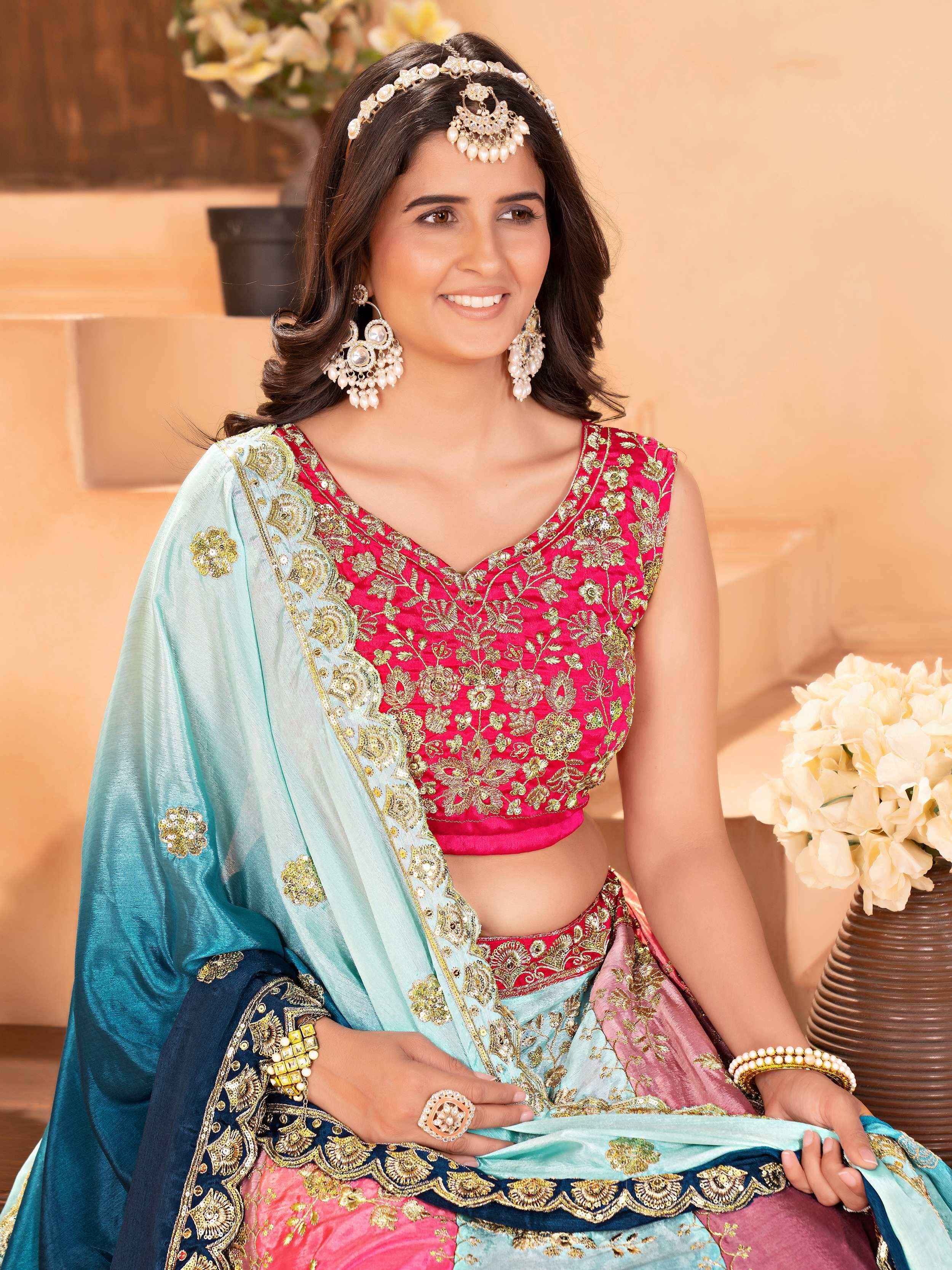 Woman in pink and blue embroidered lehenga choli with gold detailing, perfect for Indian ethnic occasions.