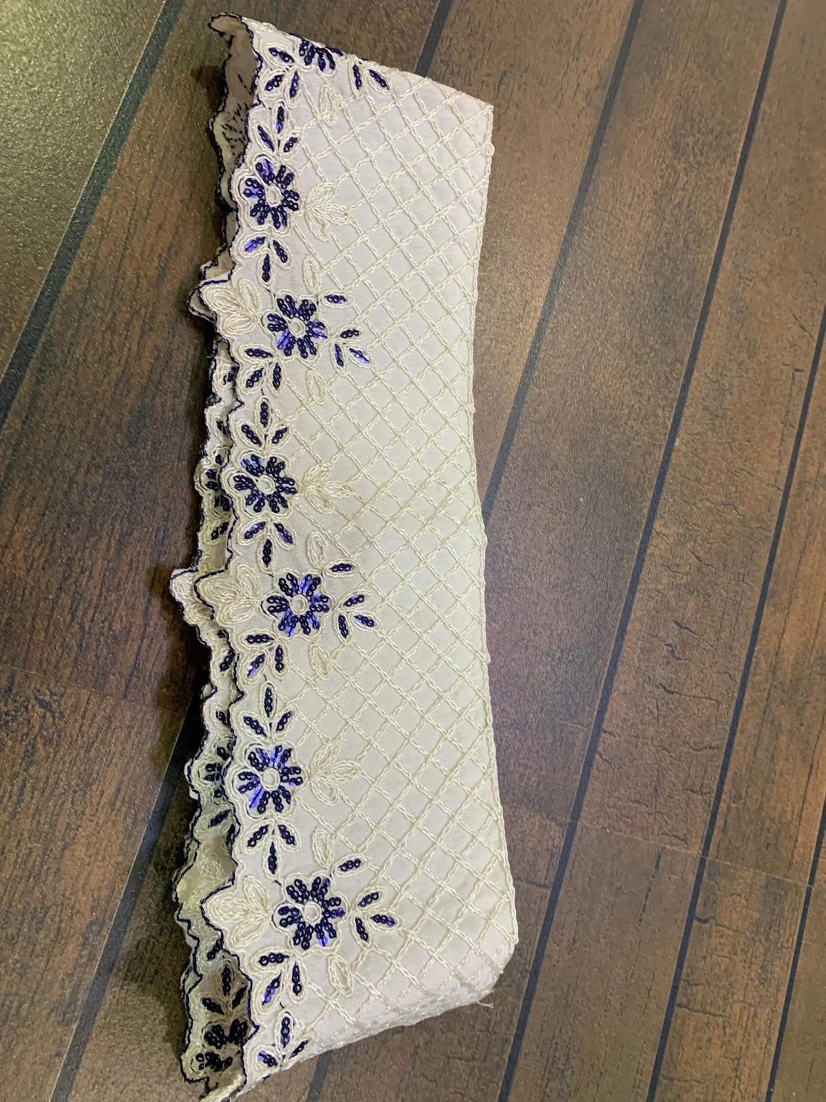 White fabric with blue floral embroidery and diamond pattern, ideal for ethnic wear designs.