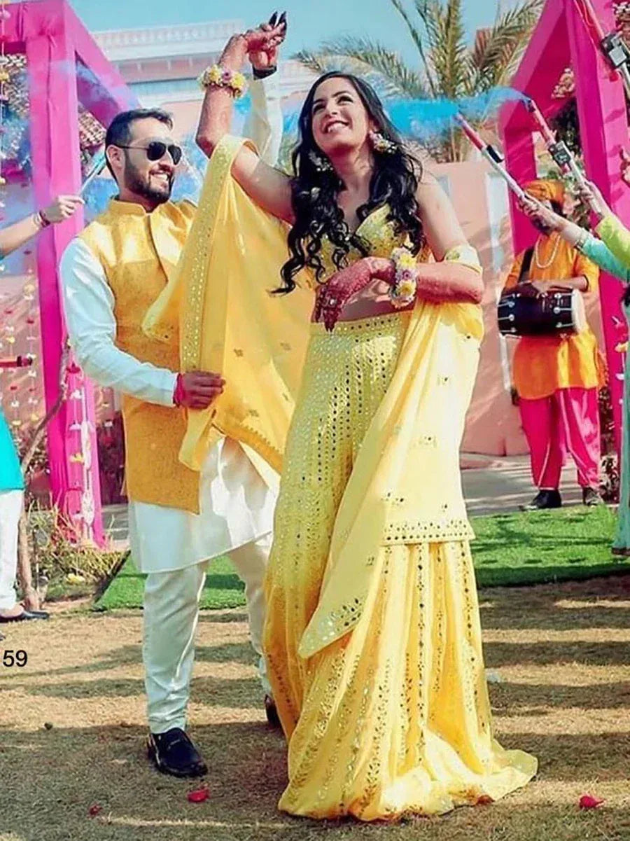 Woman in yellow designer lehenga choli dancing at outdoor Indian wedding celebration