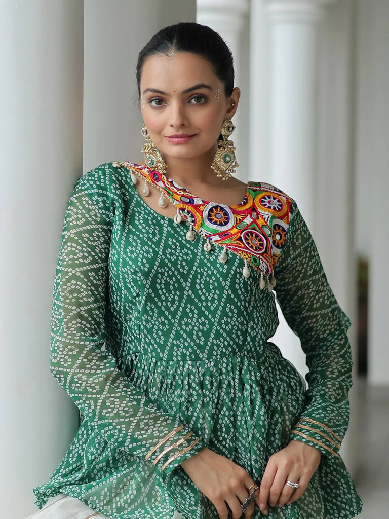 Green ethnic kurti with colorful mirror embroidery and pearl detailing, paired with statement earrings