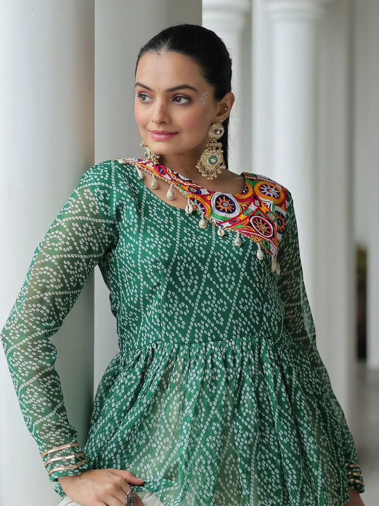 Green printed ethnic gown with colorful embroidery and traditional jewelry