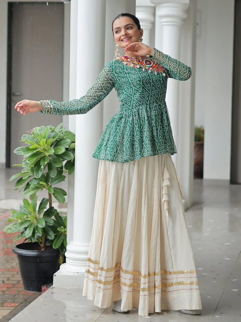 Woman in green printed peplum top with cream pleated skirt, ethnic Indian wear for festive occasions