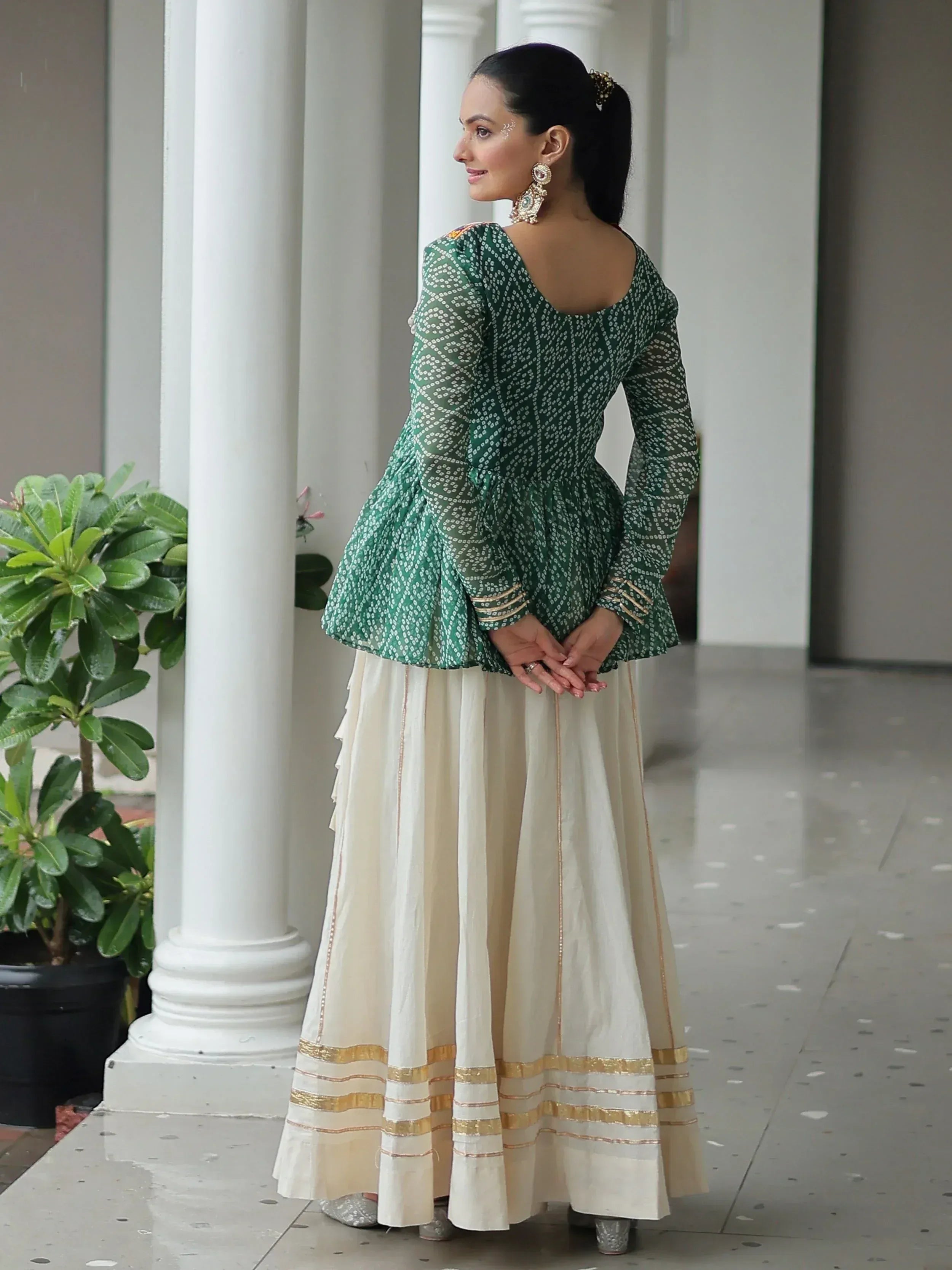 Woman in green printed peplum top with ivory skirt, ethnic Indian wear for festive occasions
