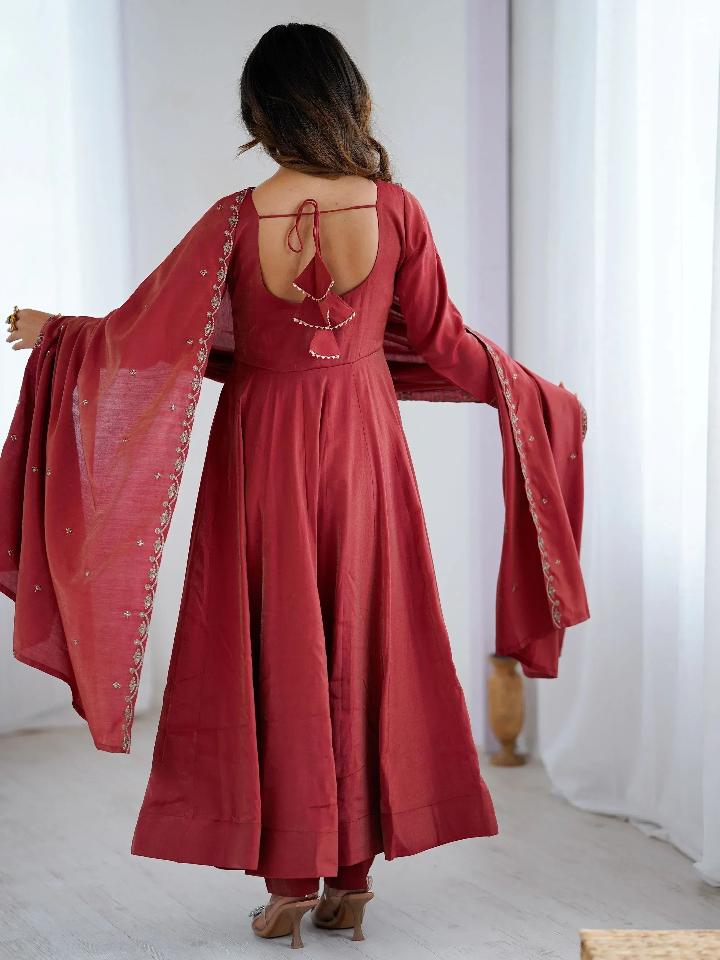Red ethnic anarkali with embroidered sleeves and open back design, paired with matching dupatta