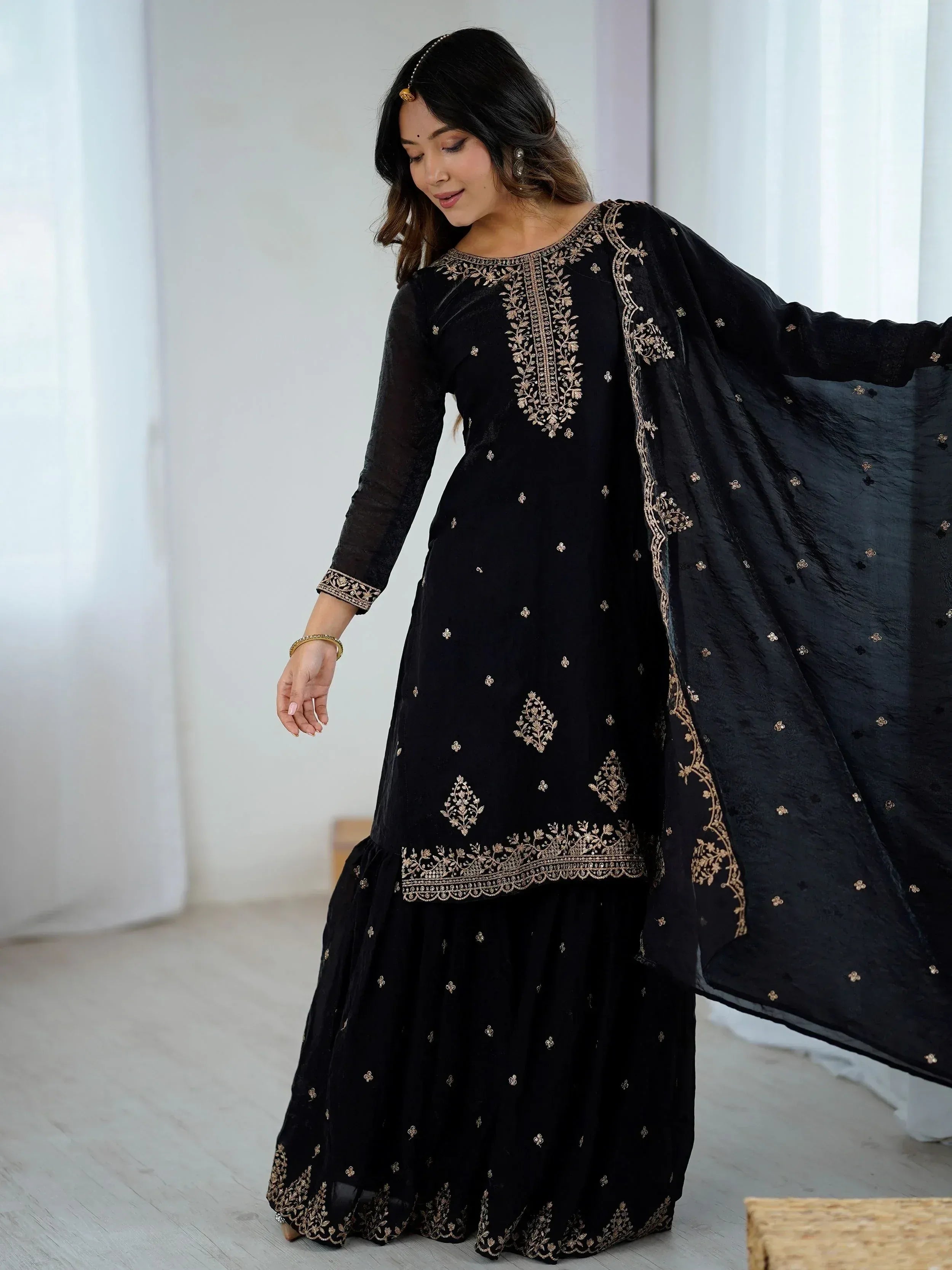 Black embroidered ethnic salwar kameez with gold detailing, perfect for festive occasions and Indian wear.