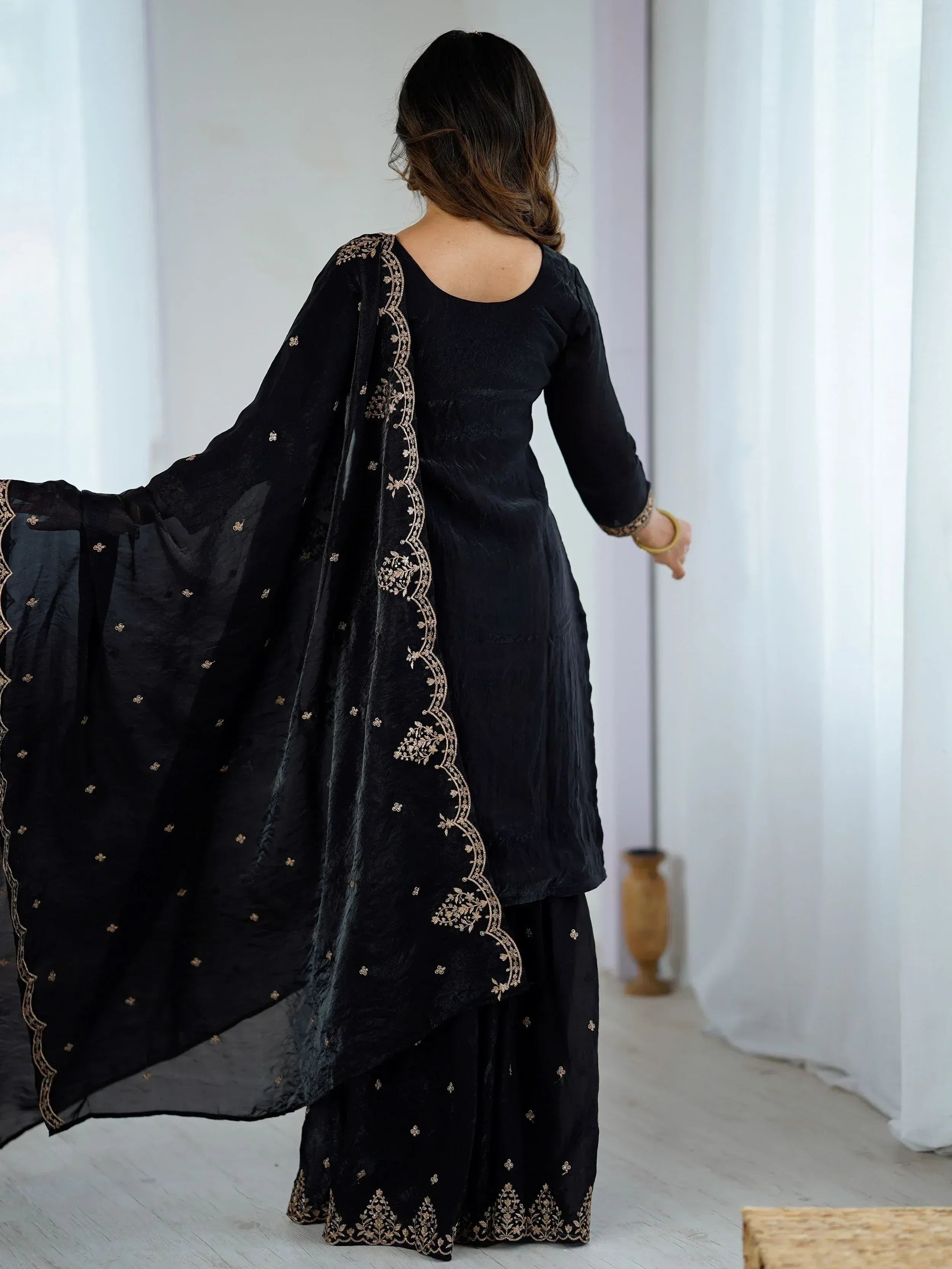 Black embroidered ethnic salwar kameez with gold detailing, perfect for Indian wear occasions.