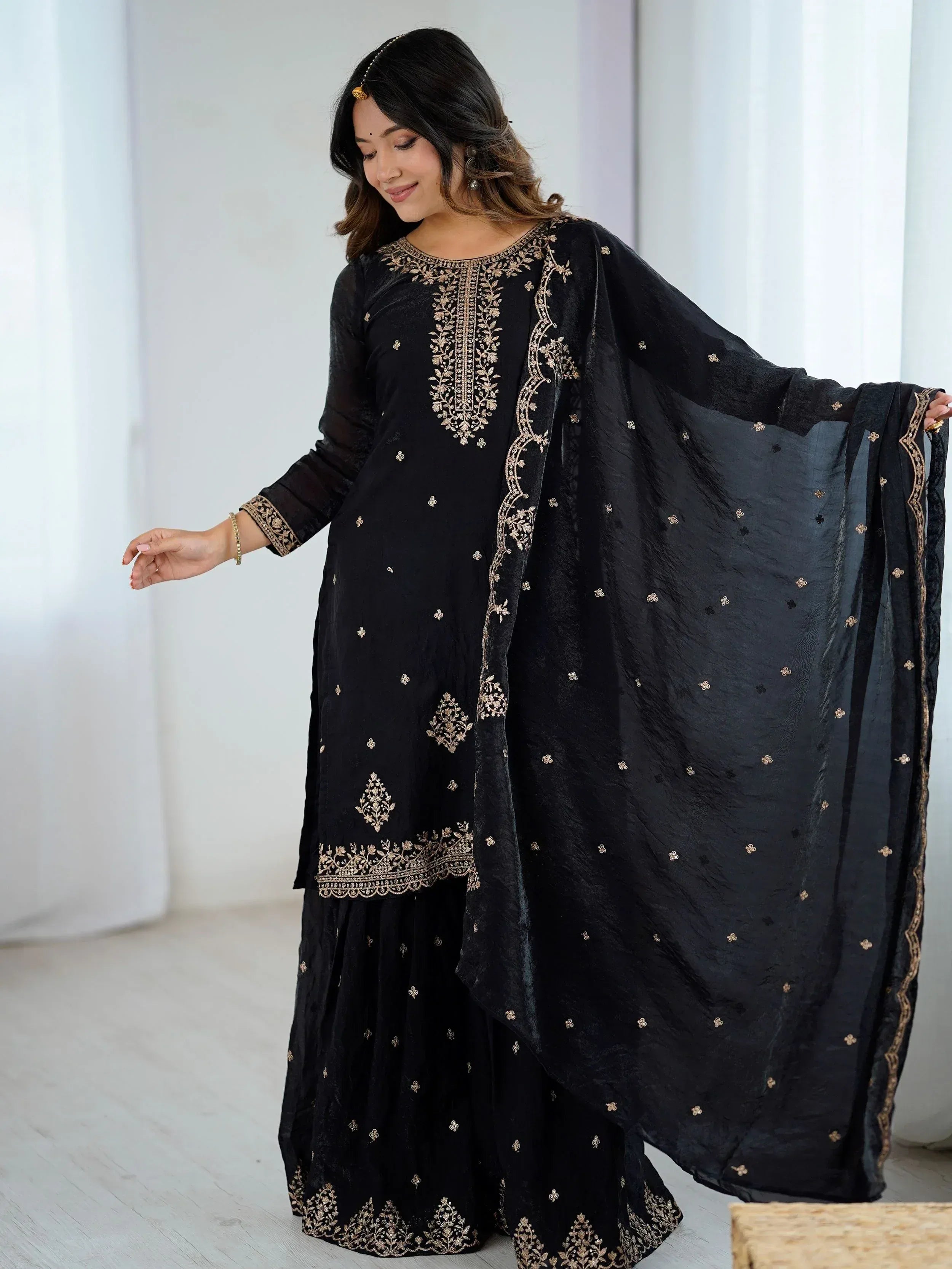 Black embroidered salwar kameez with gold detailing, perfect for ethnic occasions