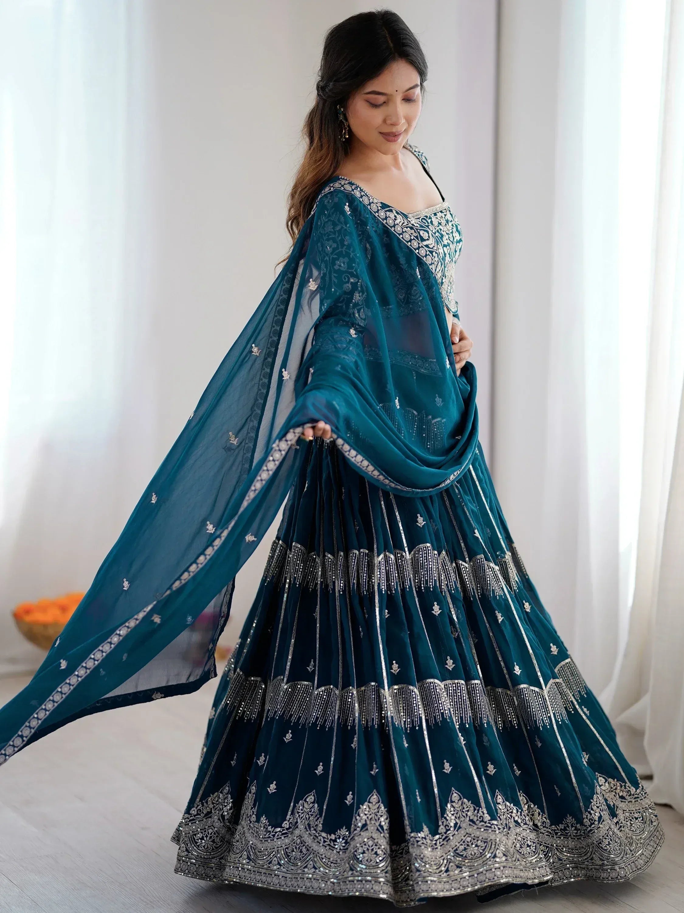 Teal designer lehenga choli with silver embroidery, perfect for Indian weddings and festive occasions.