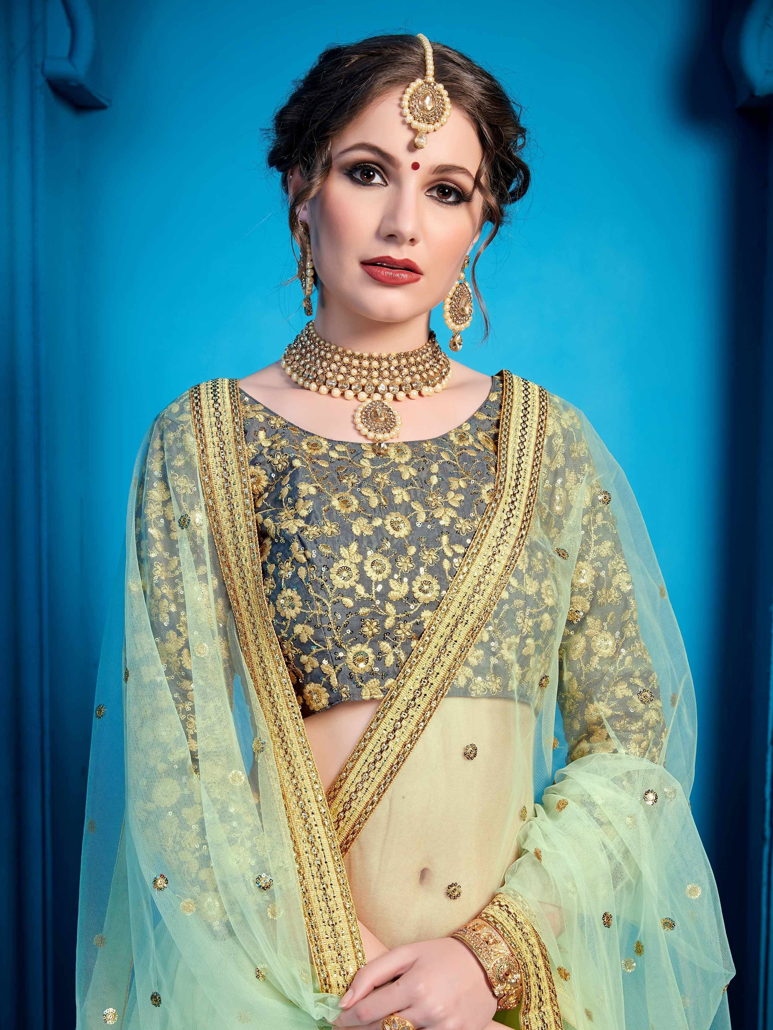 Elegant Indian ethnic wear with gold embroidery, sheer dupatta, and traditional jewelry for festive occasions