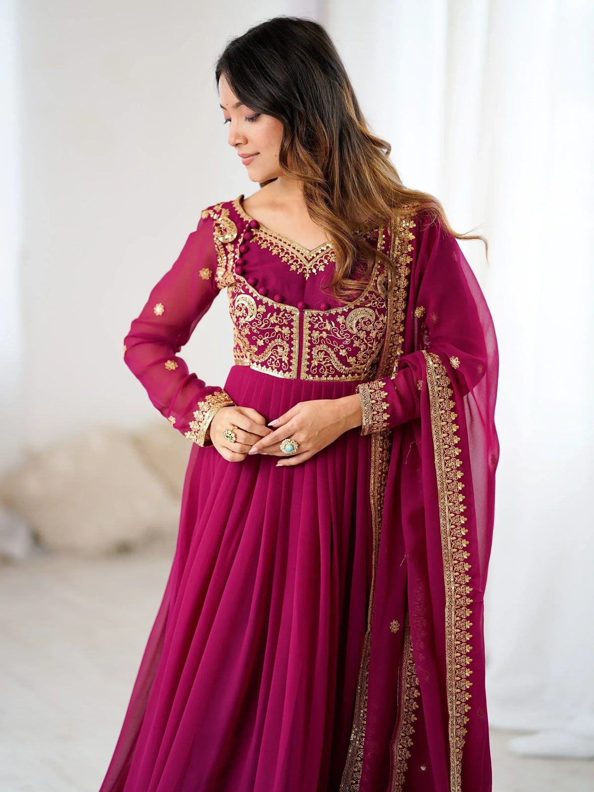 Elegant maroon Indian ethnic gown with gold embroidery, perfect for festive occasions and weddings.